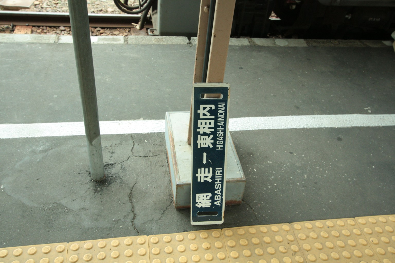 Schild auf einem Bahnsteig, das die Richtung anzeigt