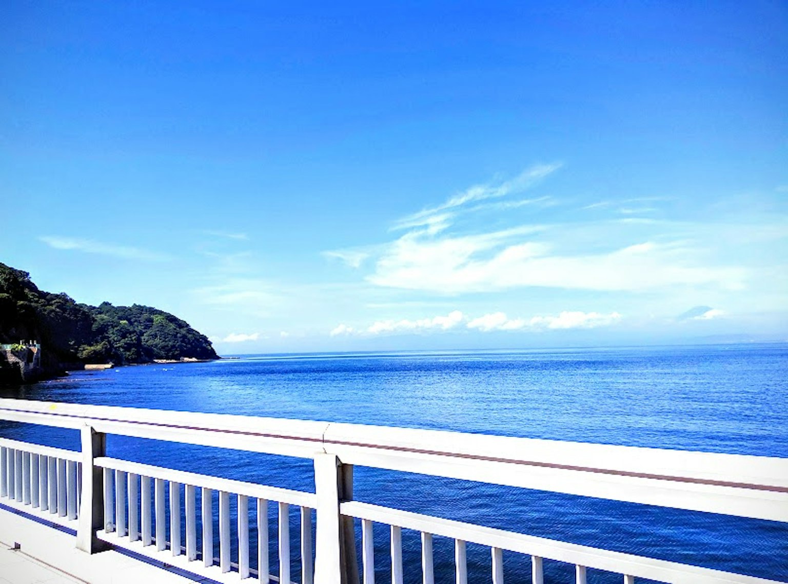 Malersicher Blick auf das blaue Meer und den Himmel mit einem weißen Geländer