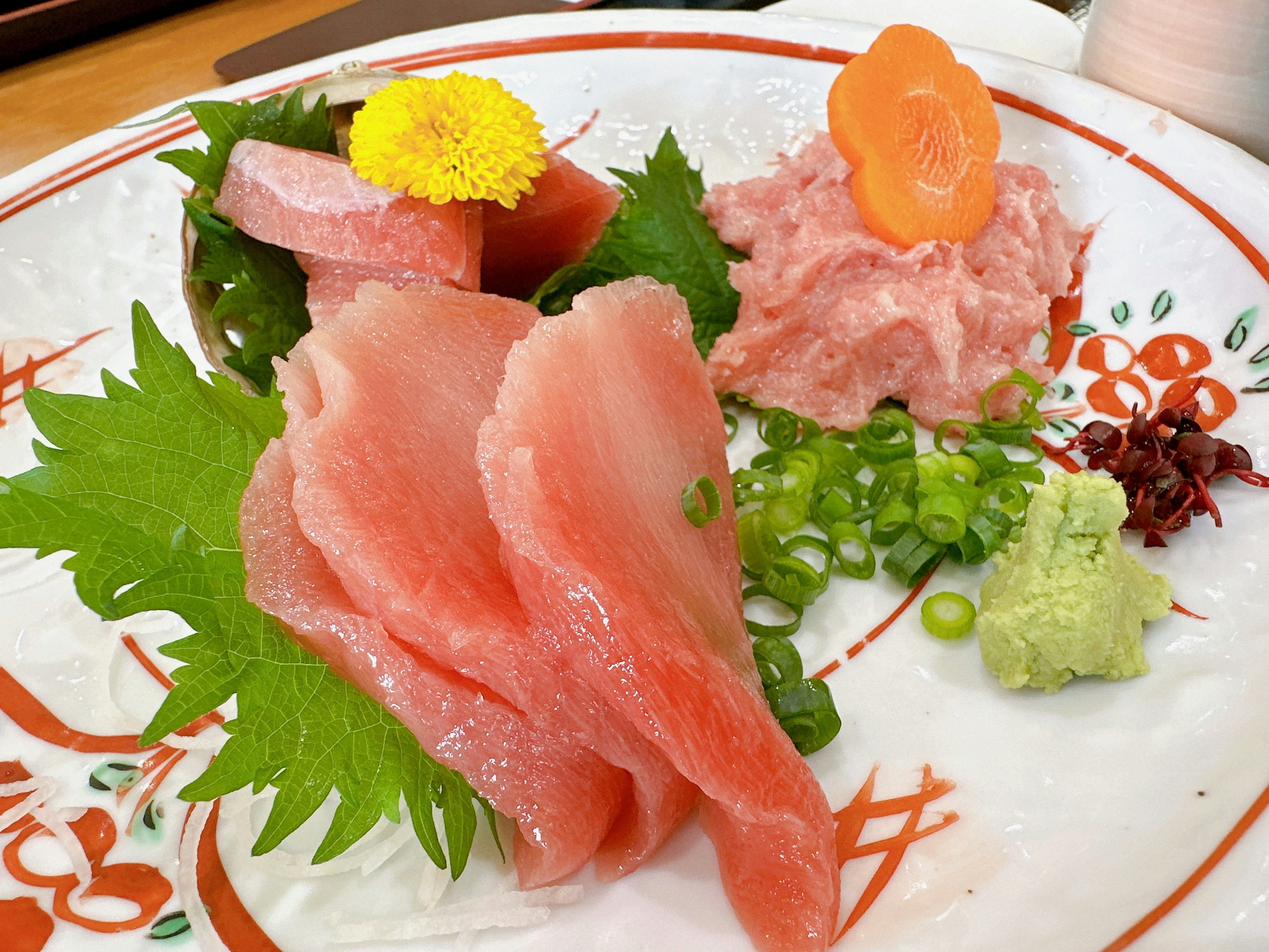 皿に盛られた刺身（マグロ）と彩りの薬味