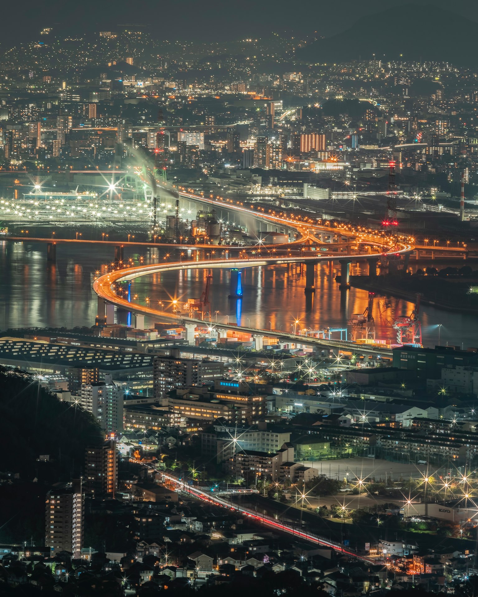 Hermosa vista nocturna de la ciudad con luces y puente sinuoso