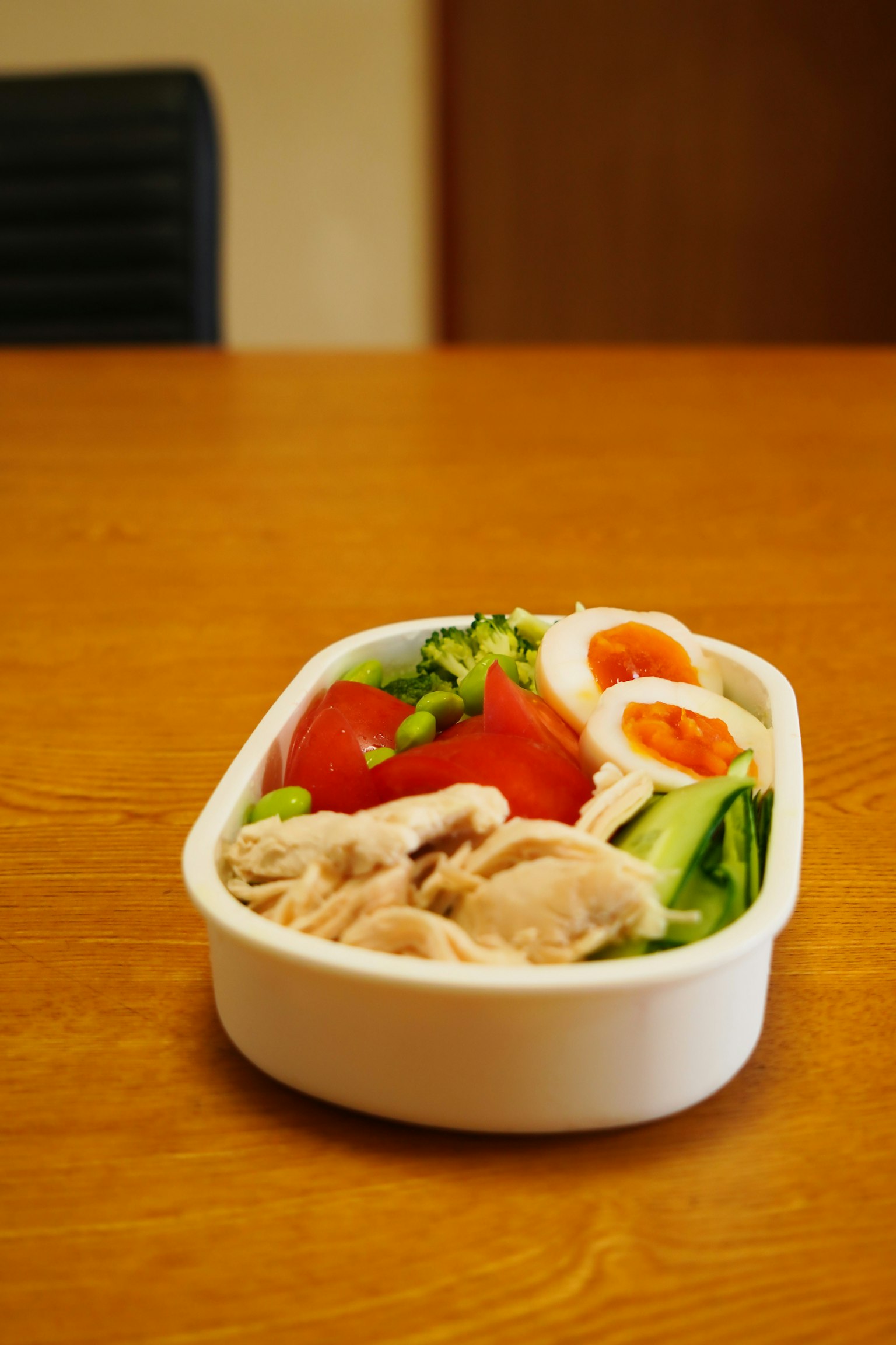 一个装满新鲜蔬菜和肉类菜肴的白色午餐盒
