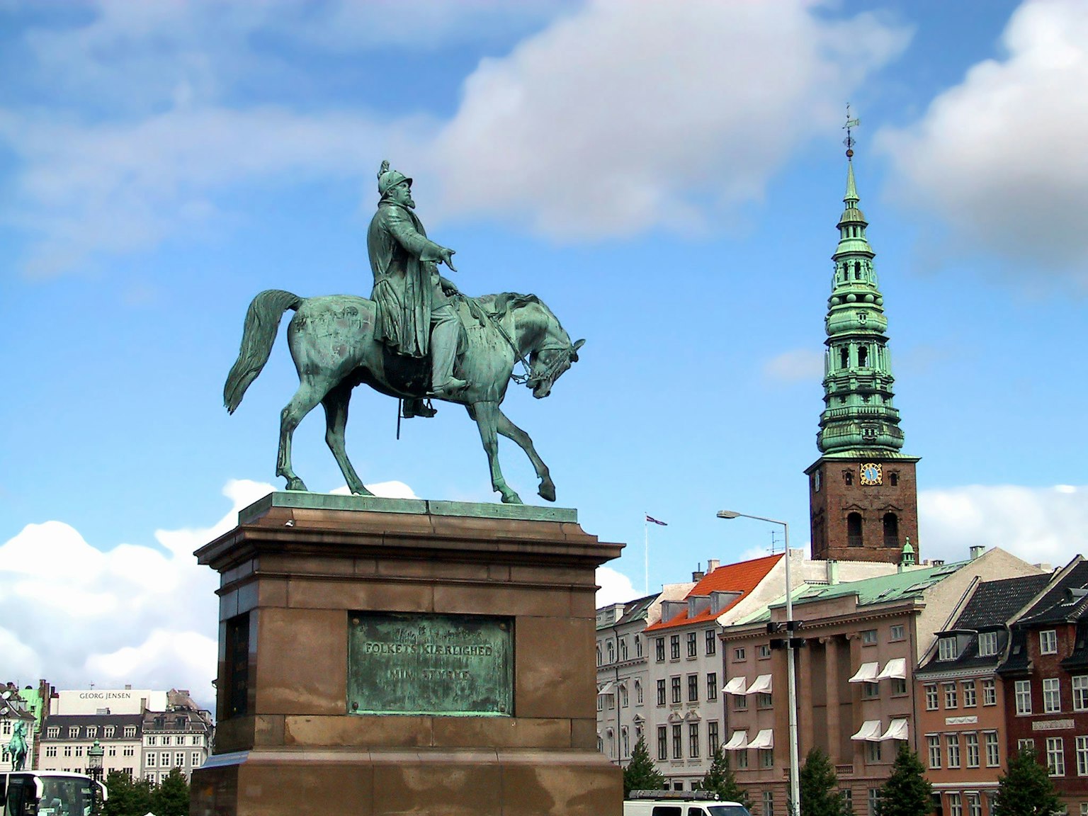 Bronzestatue eines Königs zu Pferd mit historischen Gebäuden im Hintergrund