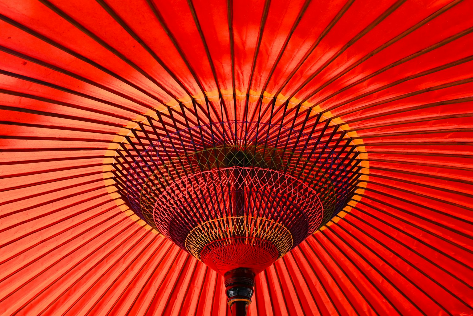 红色日本伞的内部视图，展示放射状图案和装饰元素