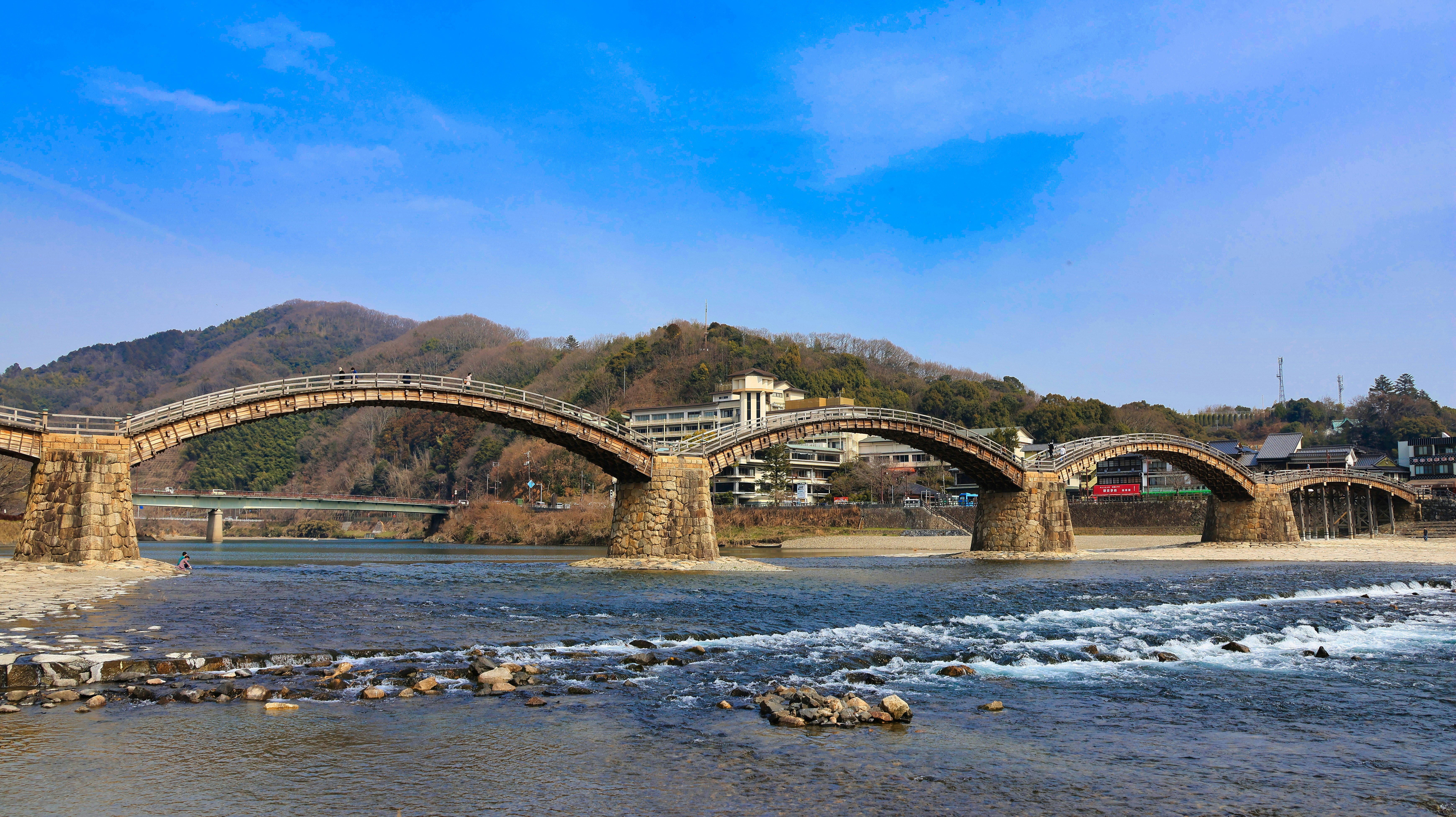 川にかかる石造りのアーチ橋と川岸の岩
