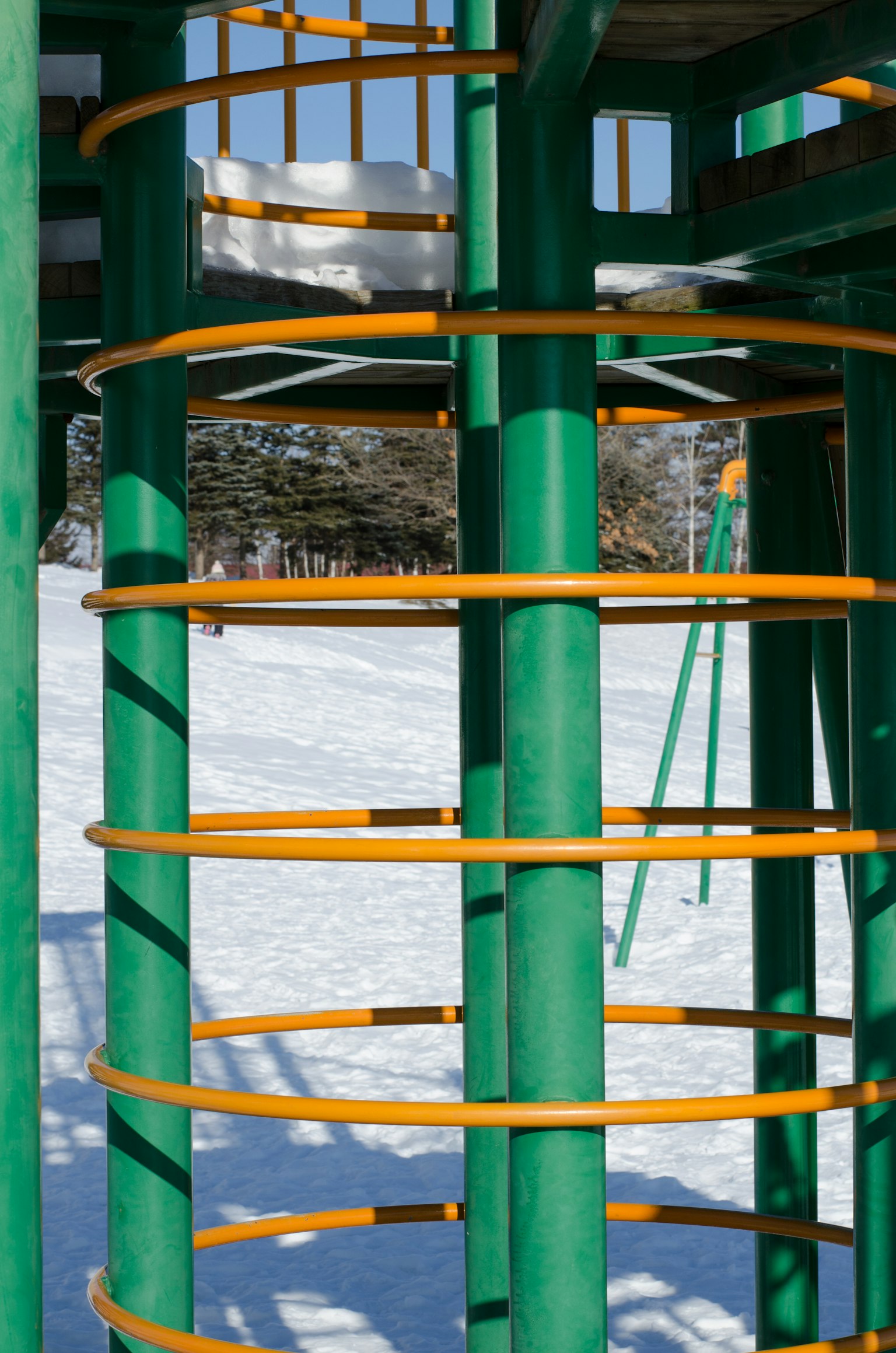 Parte di una struttura di gioco verde e arancione sulla neve