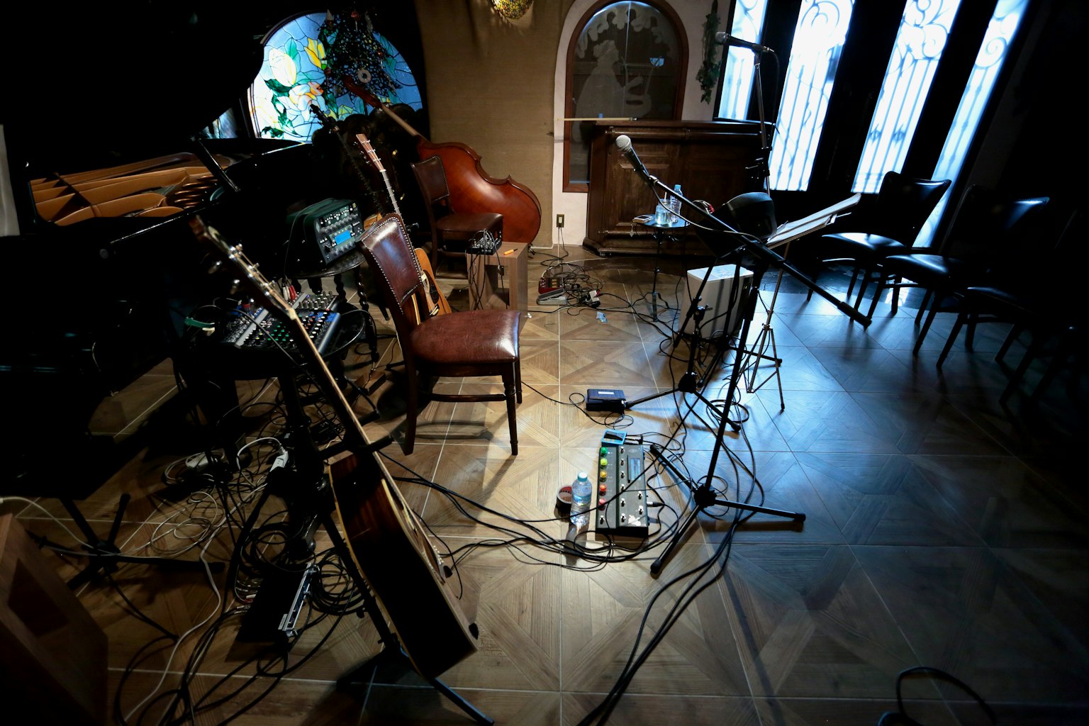 Interior of a music studio featuring chairs and instruments with cables and equipment arranged