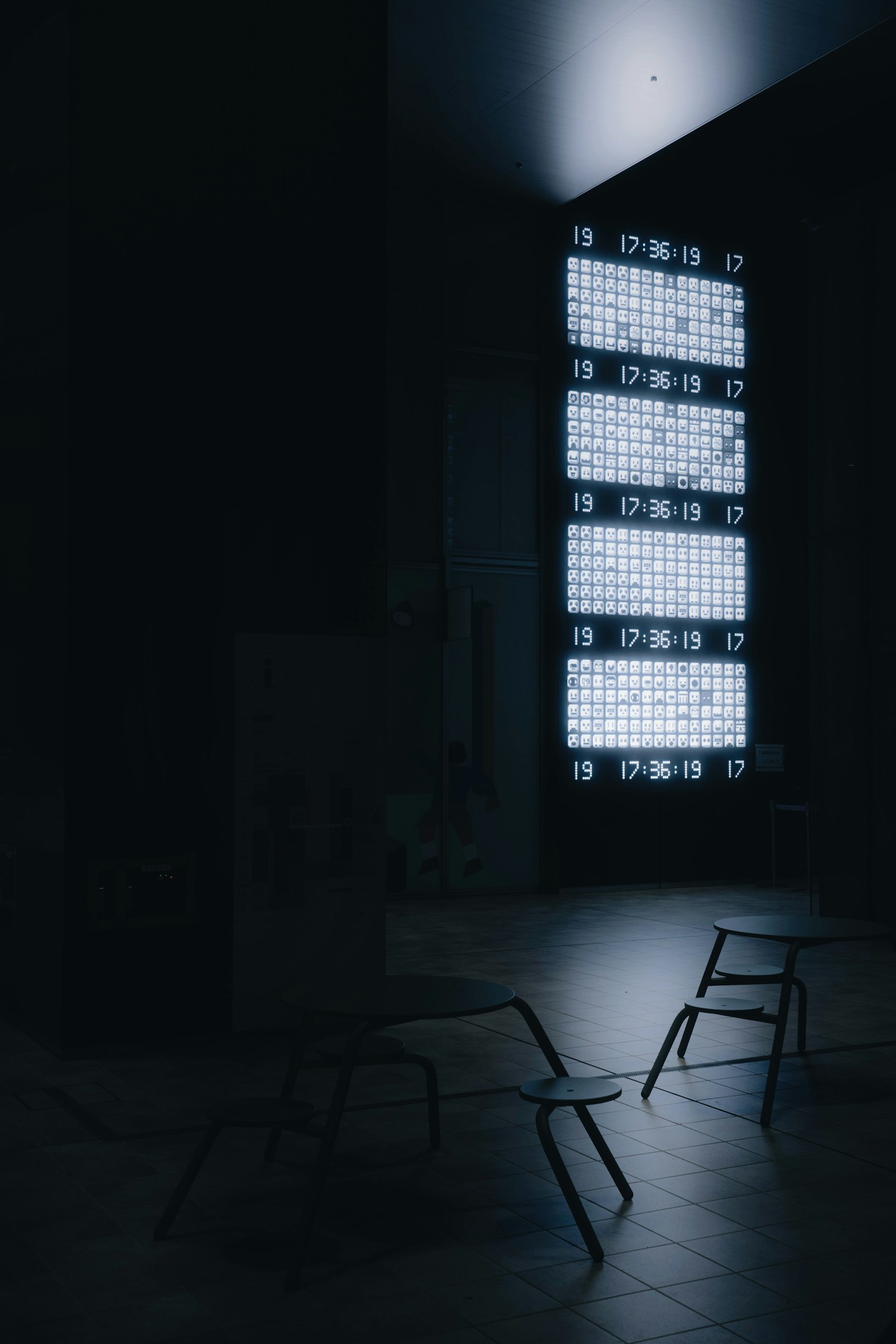Sedie metalliche in una stanza buia illuminate da finestre luminose