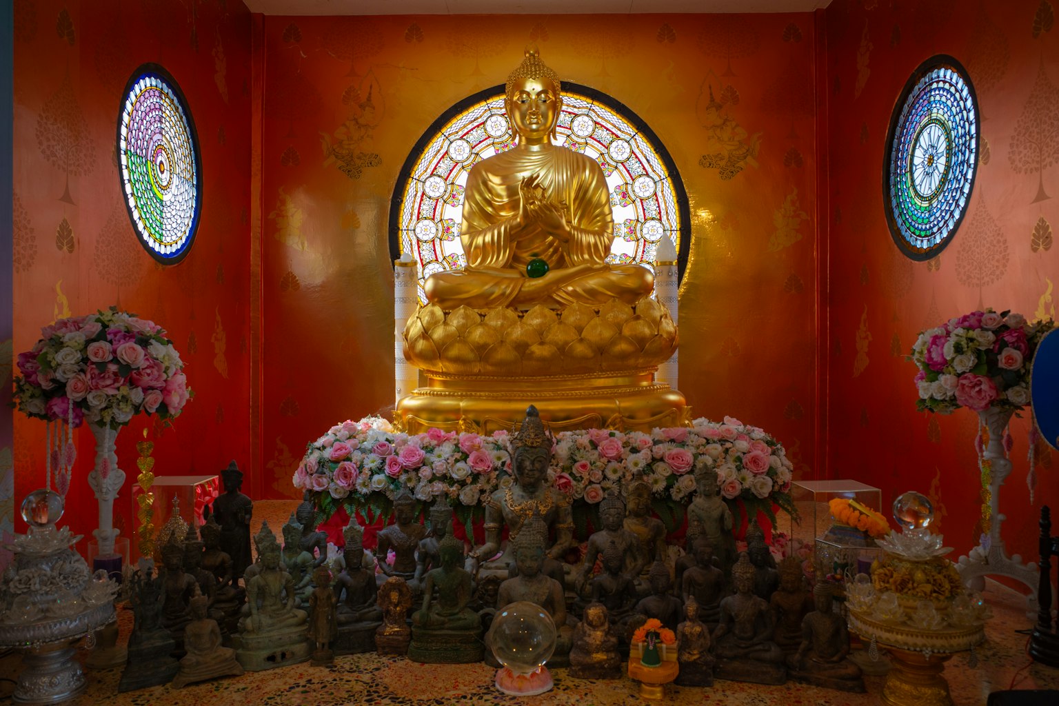 中央有金色佛像，周圍有花卉裝飾的佛教祭壇