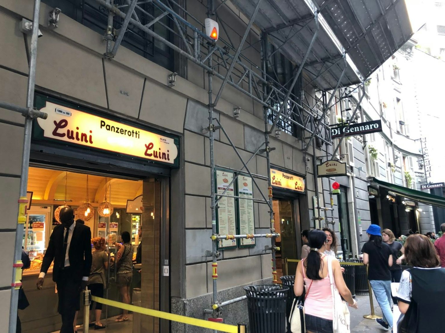 鲁伊尼店铺的外观和排队顾客的场景