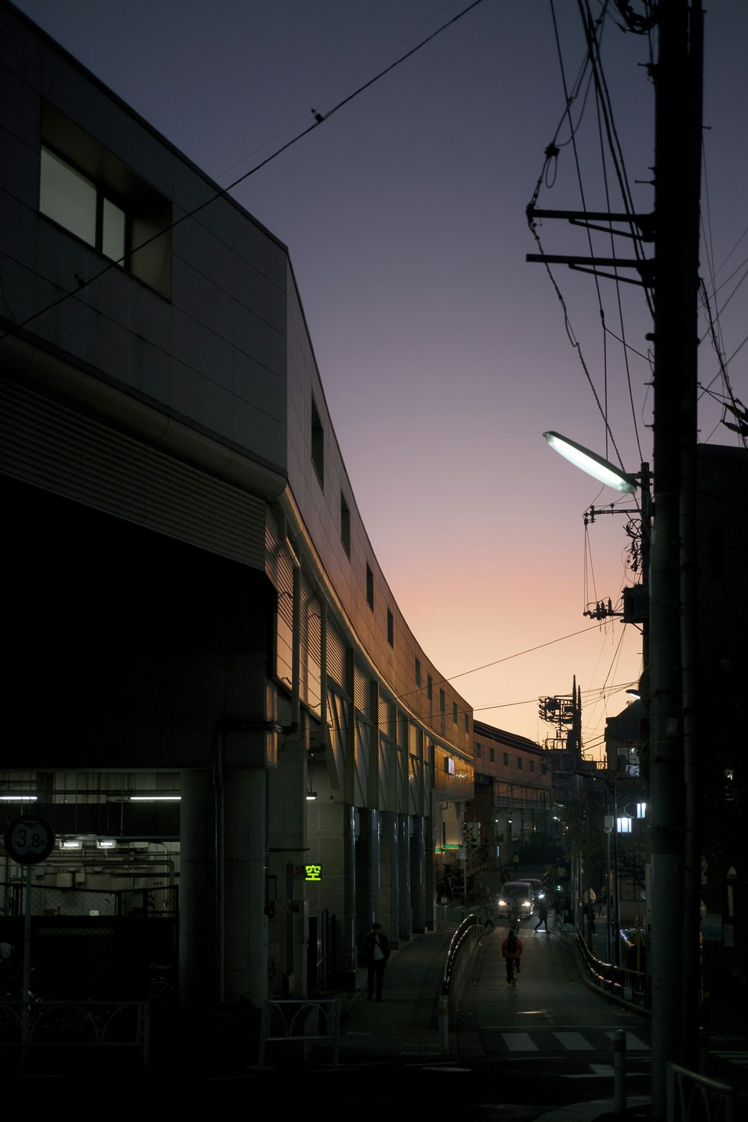 夕暮れの路地に並ぶ建物と街灯のある通り