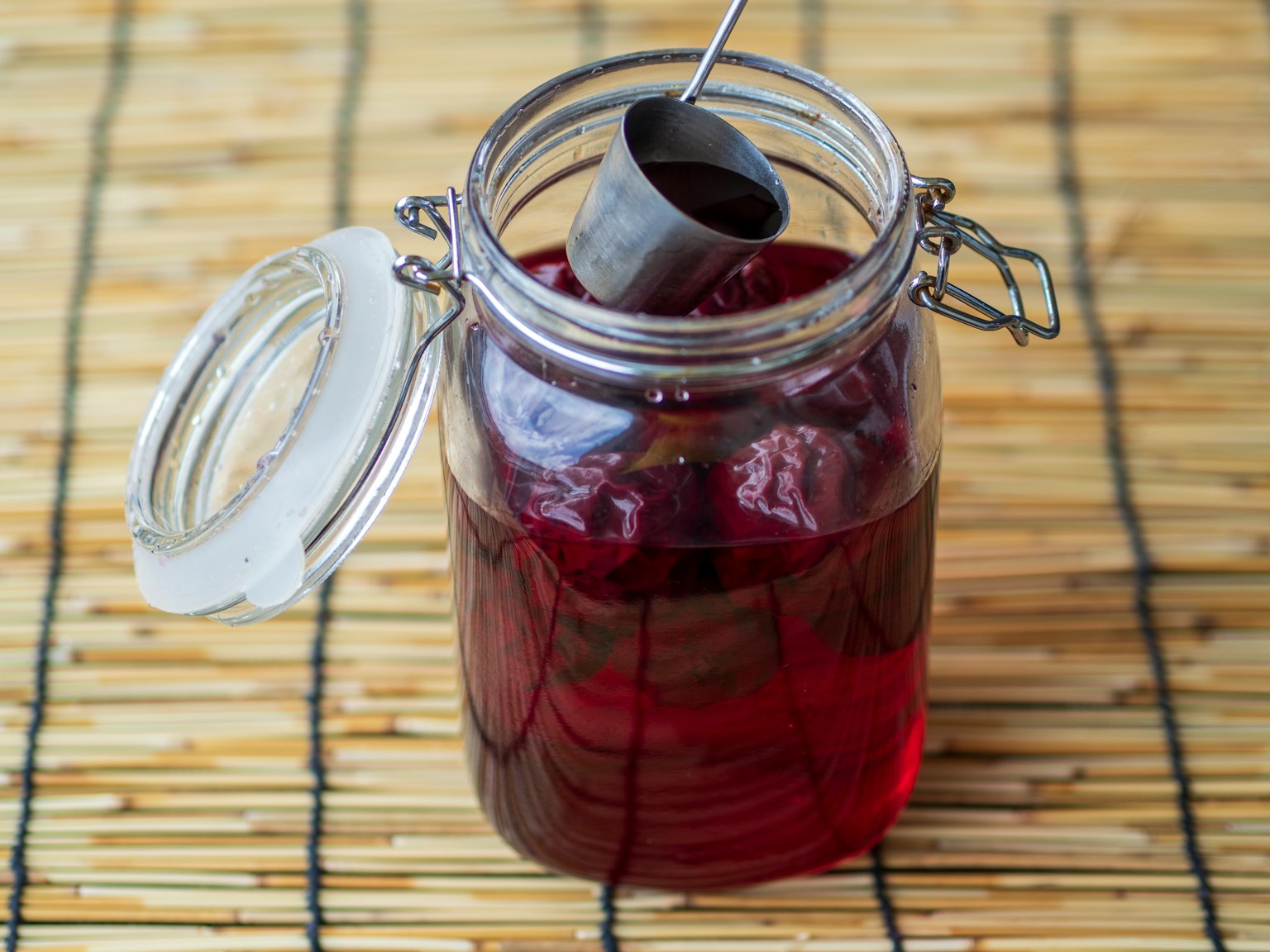 Bocal en verre rempli de liquide rouge et cuillère en métal