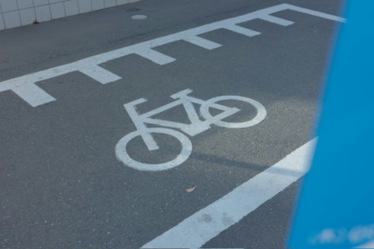 Bicycle lane marking on the road with a blue background
