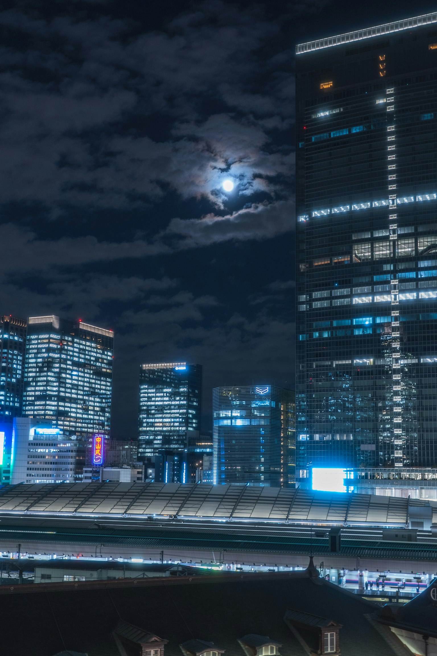 夜間城市景觀，月亮與摩天大樓