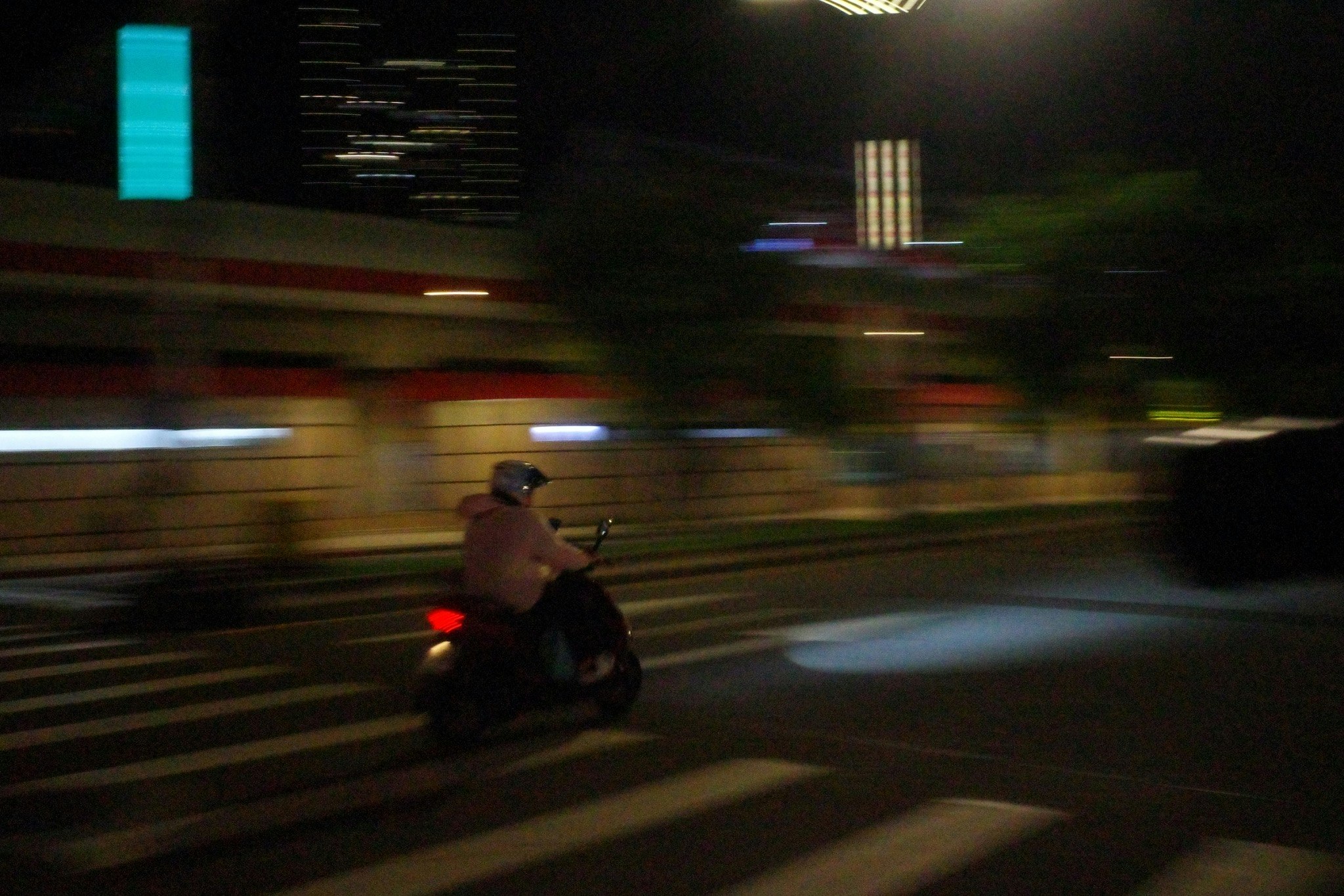 夜の横断歩道を走るバイクのある交差点