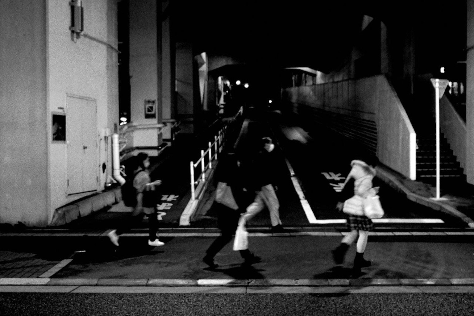 Silhouette di persone che corrono in un ambiente urbano scuro