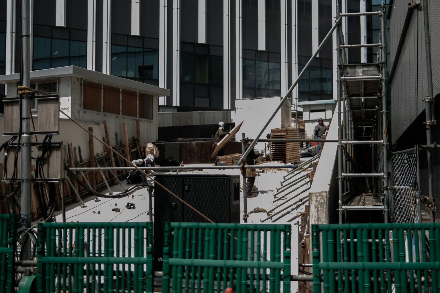 Baustelle mit grünen Zäunen und einem Arbeiter