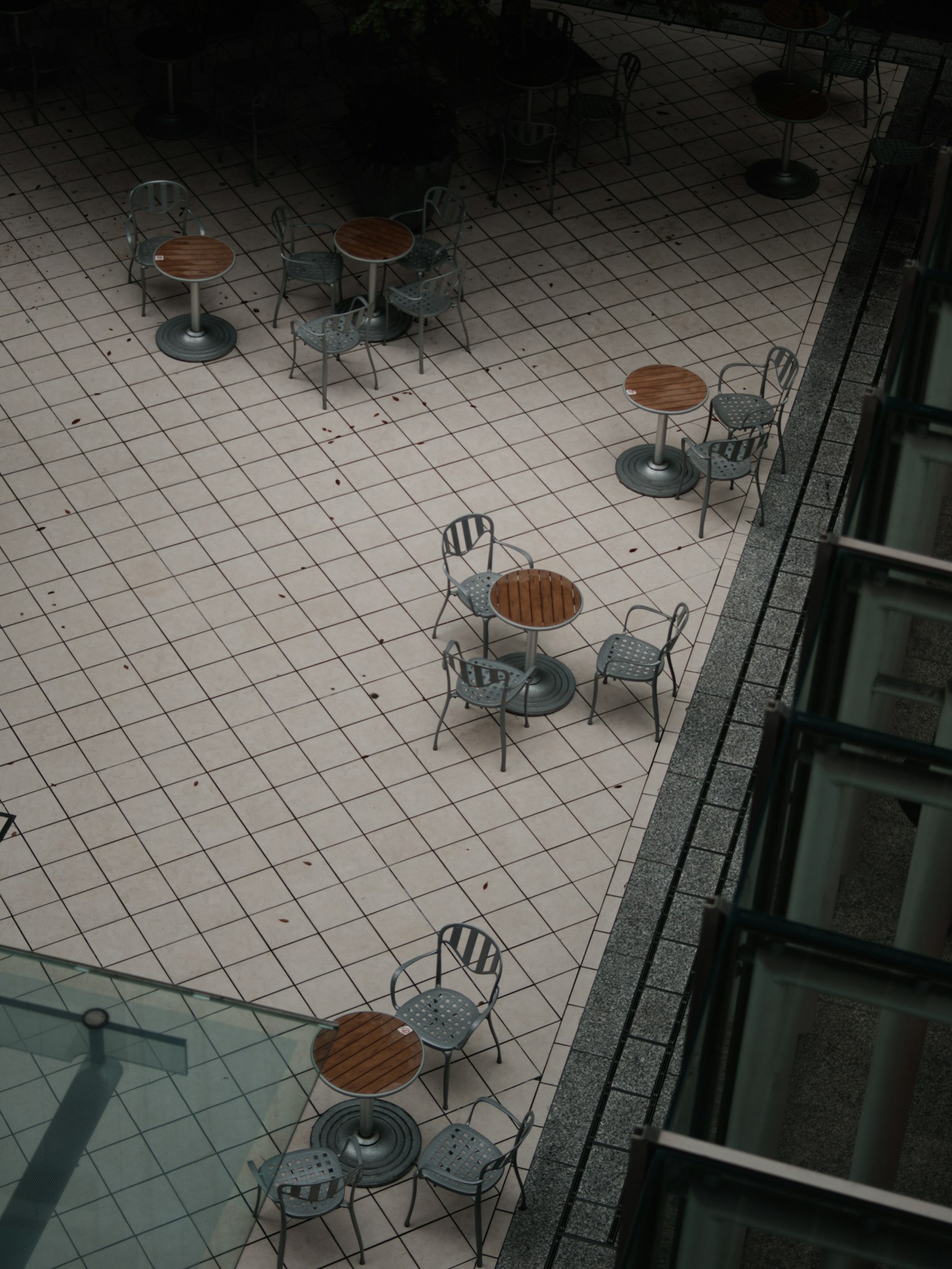 Aerial view of outdoor café tables and chairs in a tiled courtyard