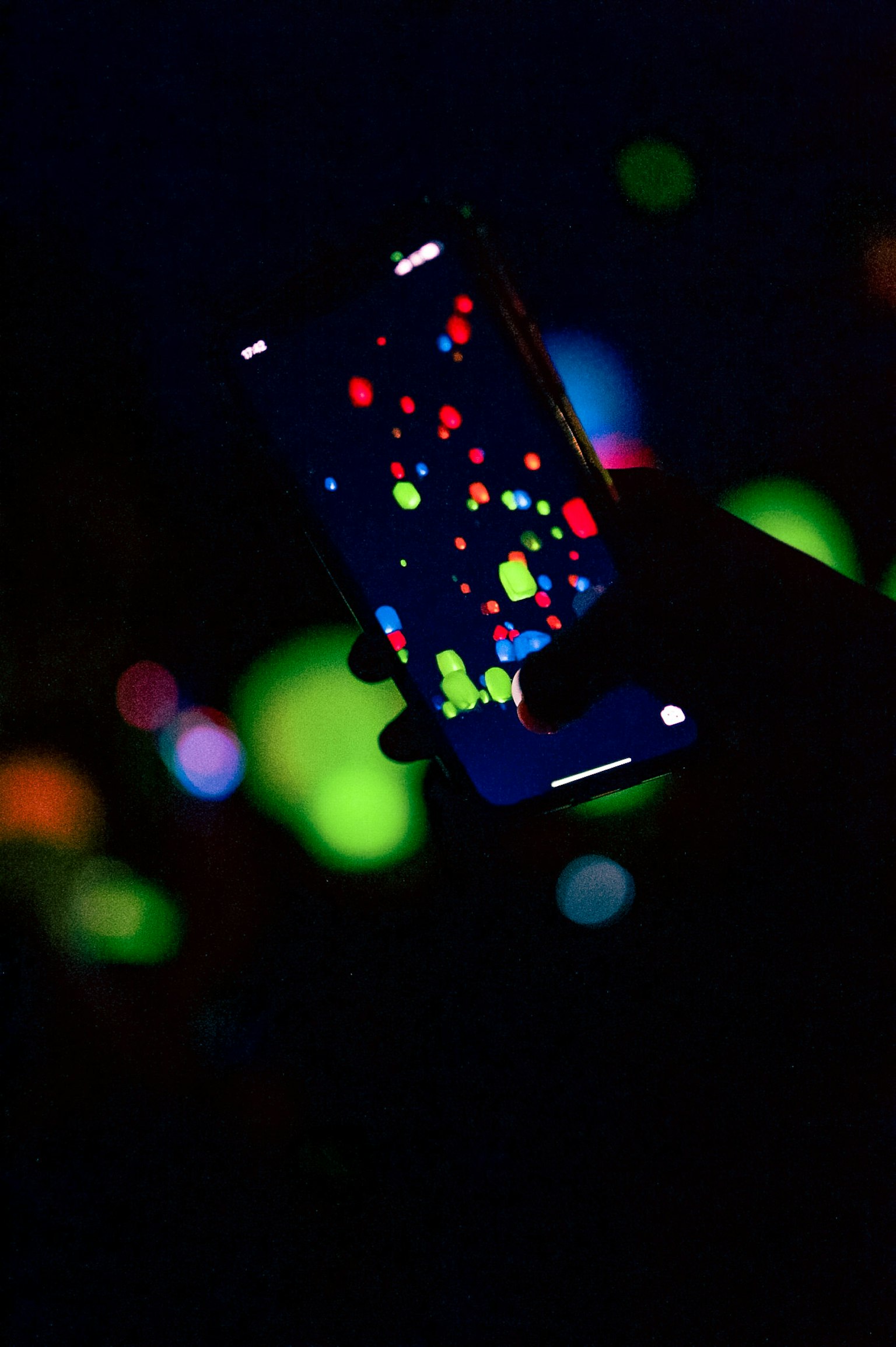 Pantalla de smartphone que muestra puntos coloridos contra un fondo oscuro