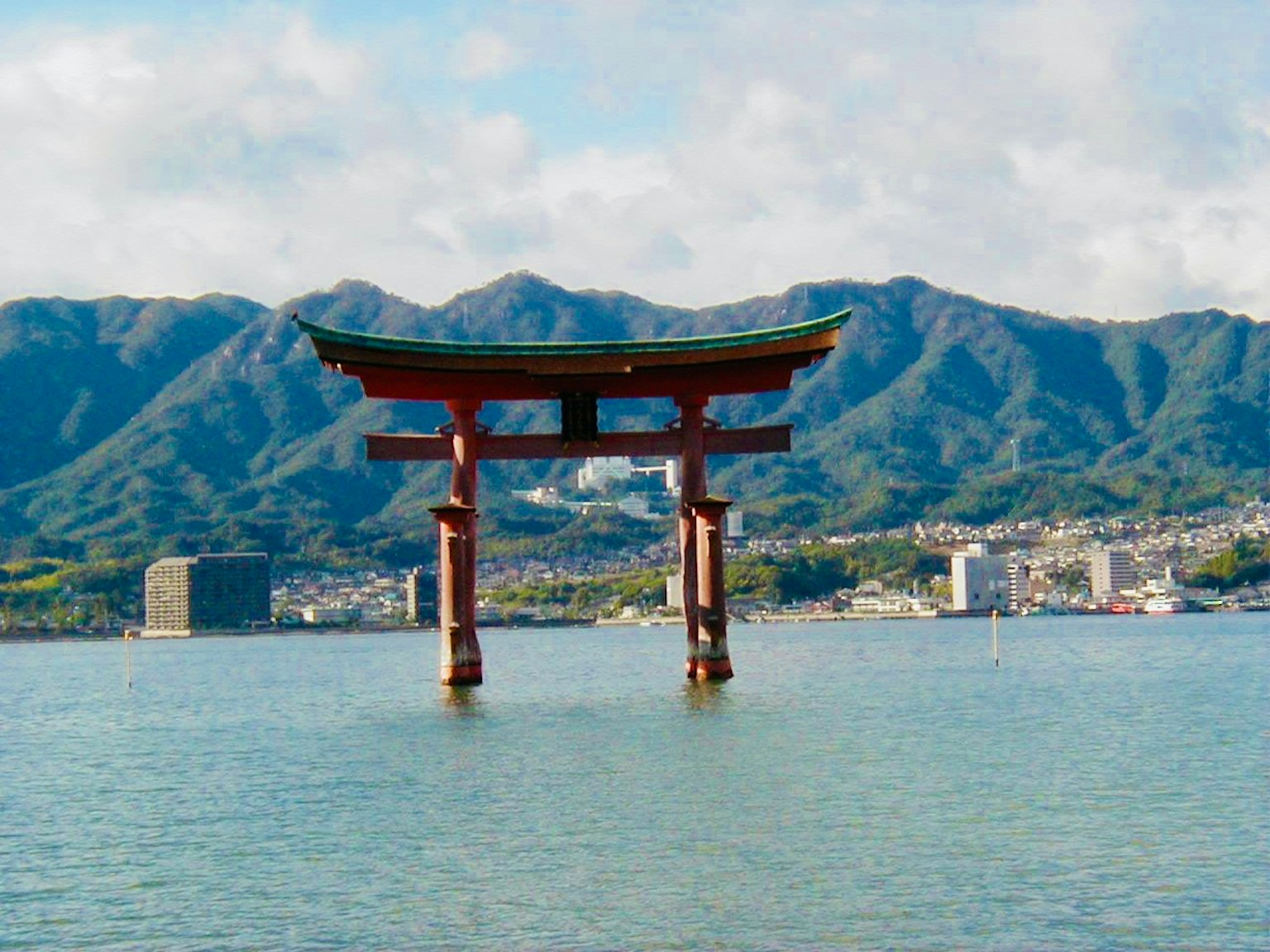 Rotes Torii im Meer mit Bergen im Hintergrund