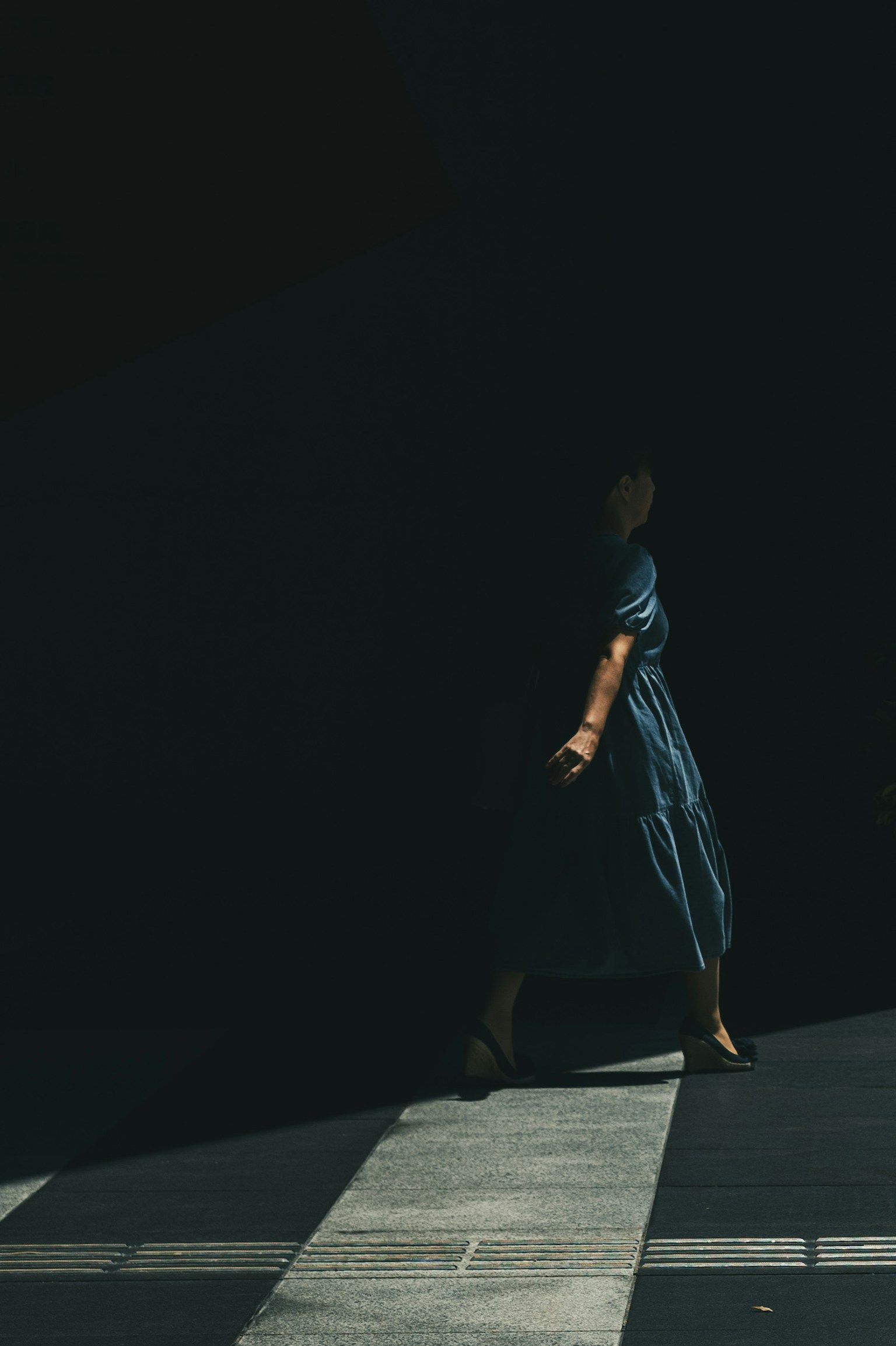 Una donna che cammina contro uno sfondo scuro