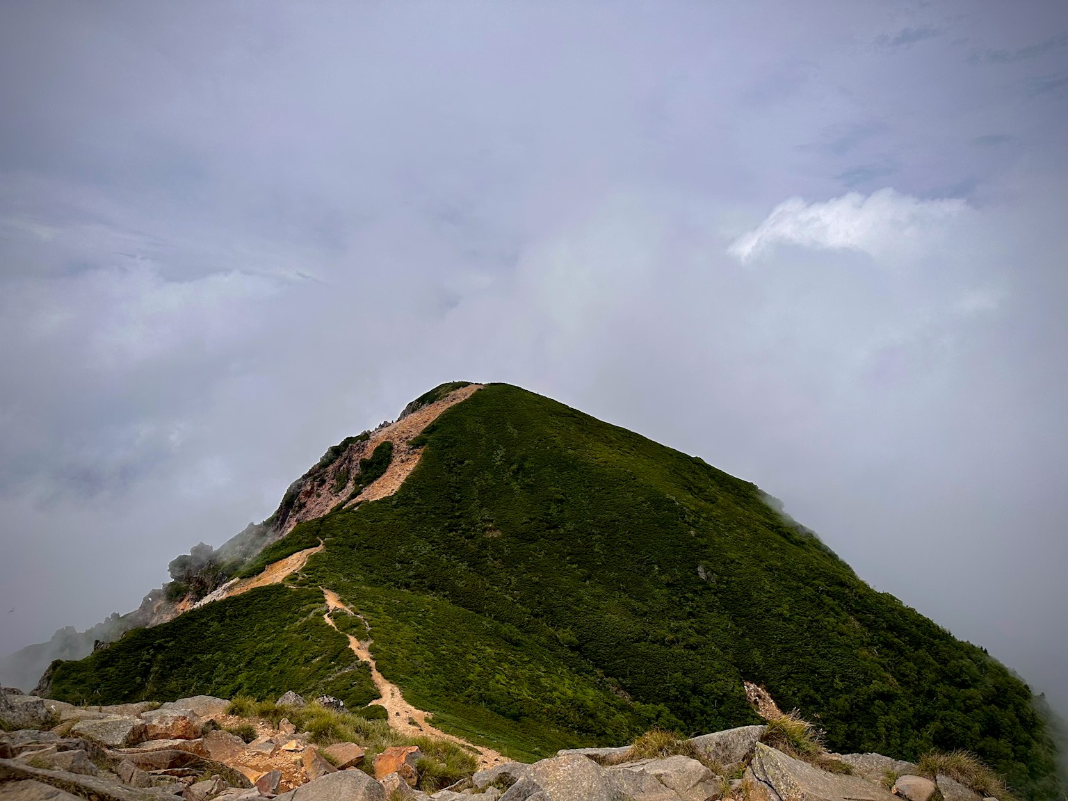 Paysage de montagne verte sous un ciel nuageux chemin menant au sommet