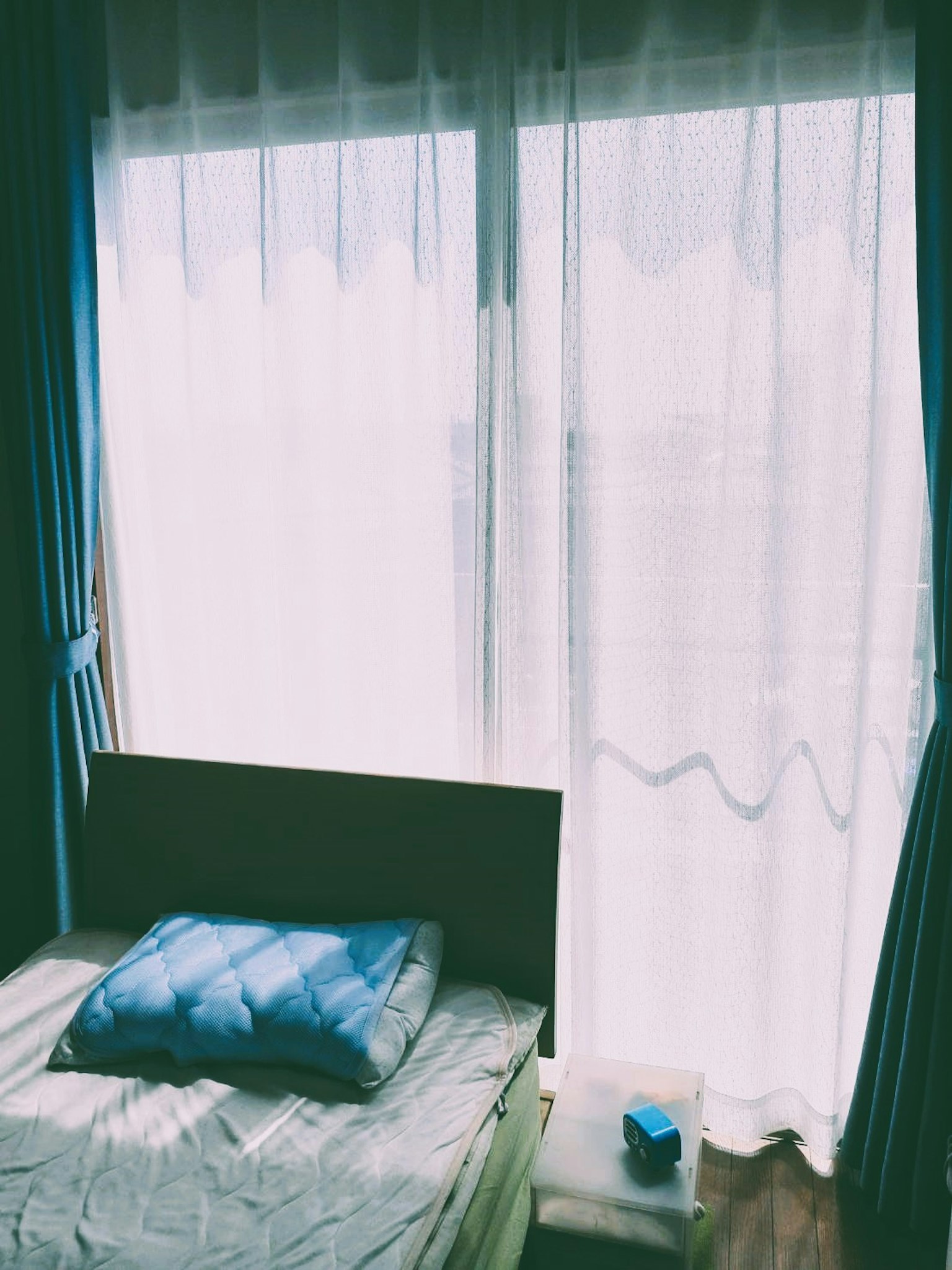 Bright bedroom with sheer curtains blue pillow on the bed