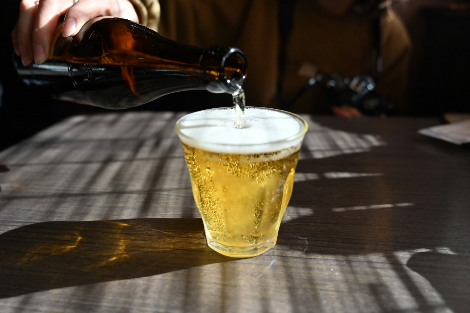 金色啤酒倒入杯中，光影交錯