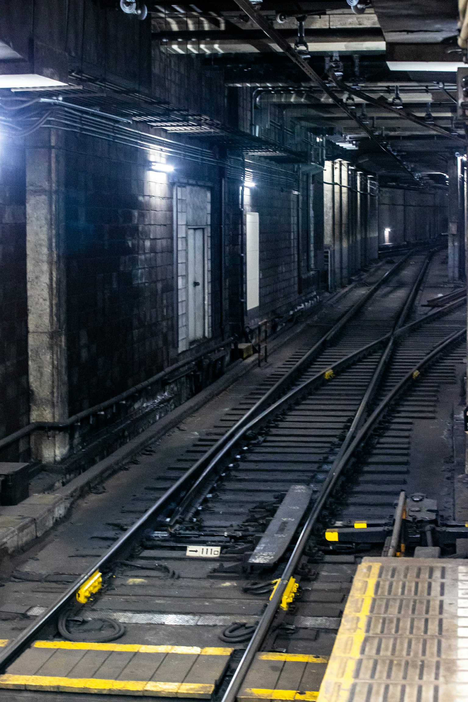 Túnel de estación de metro oscuro con vías visibles
