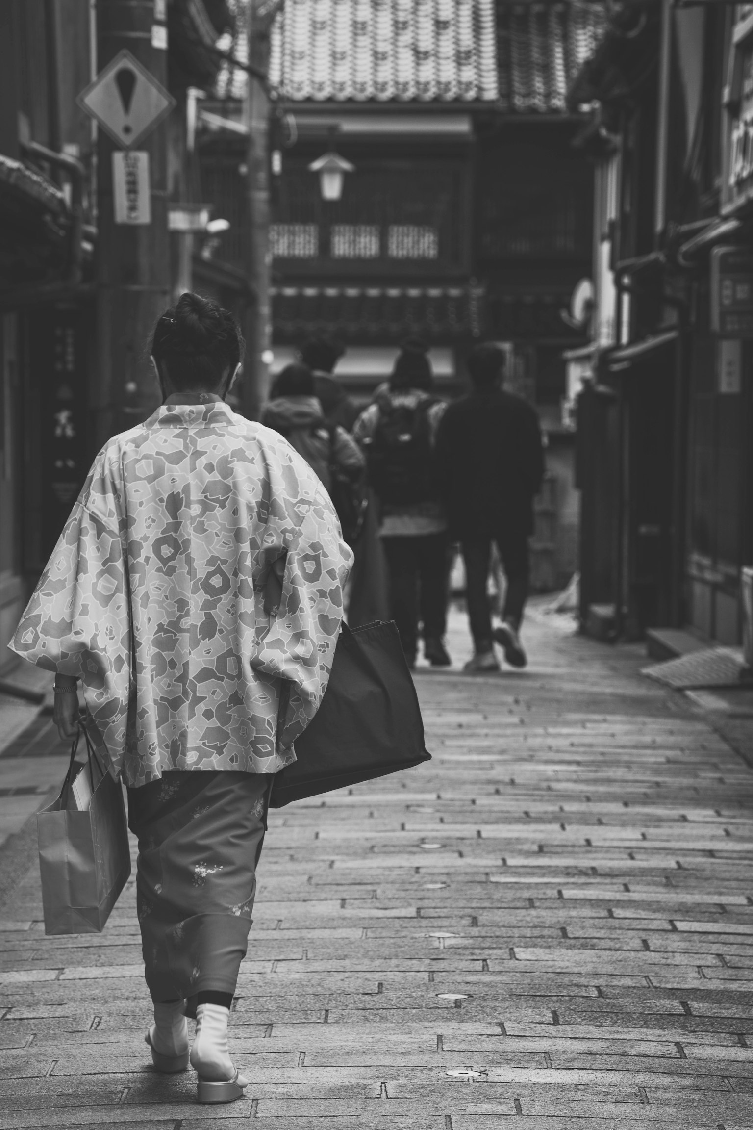 一位穿著和服的女性走在老街上