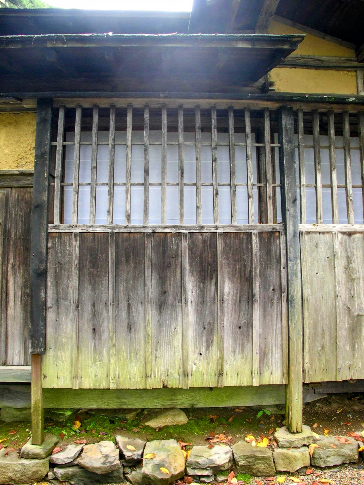 Foto einer alten Holzwand mit einem vergitterten Fenster