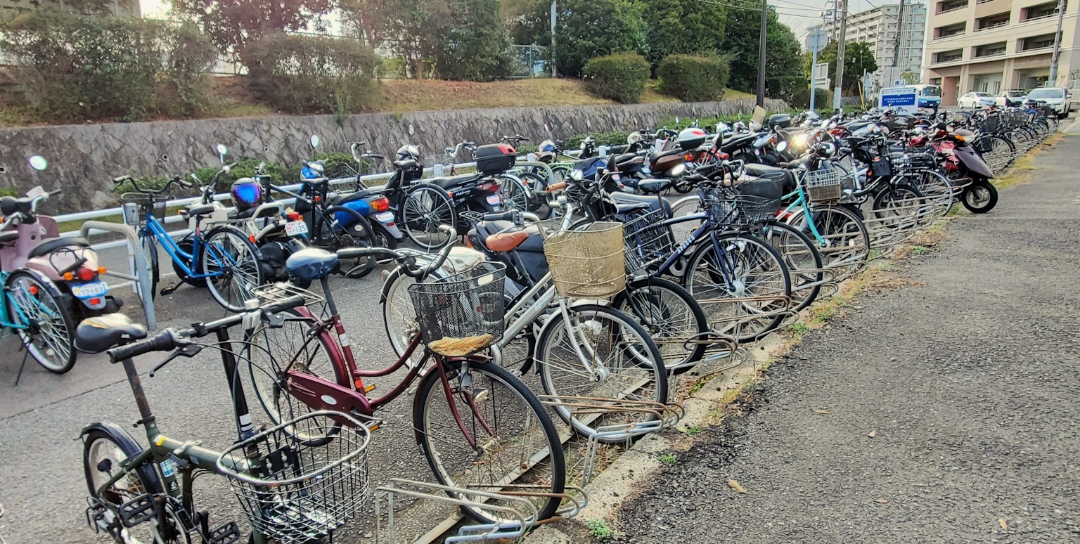 A view of a bicycle parking area filled with various bicycles
