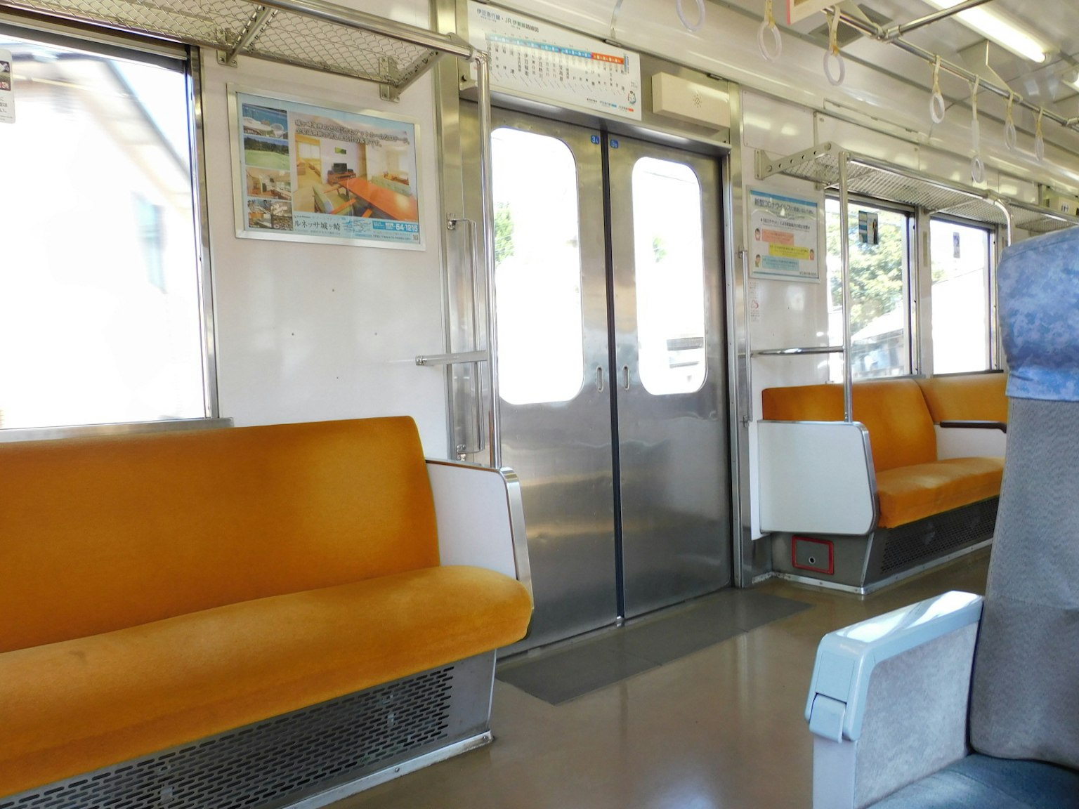 帶有橙色座椅和金屬門的火車內部