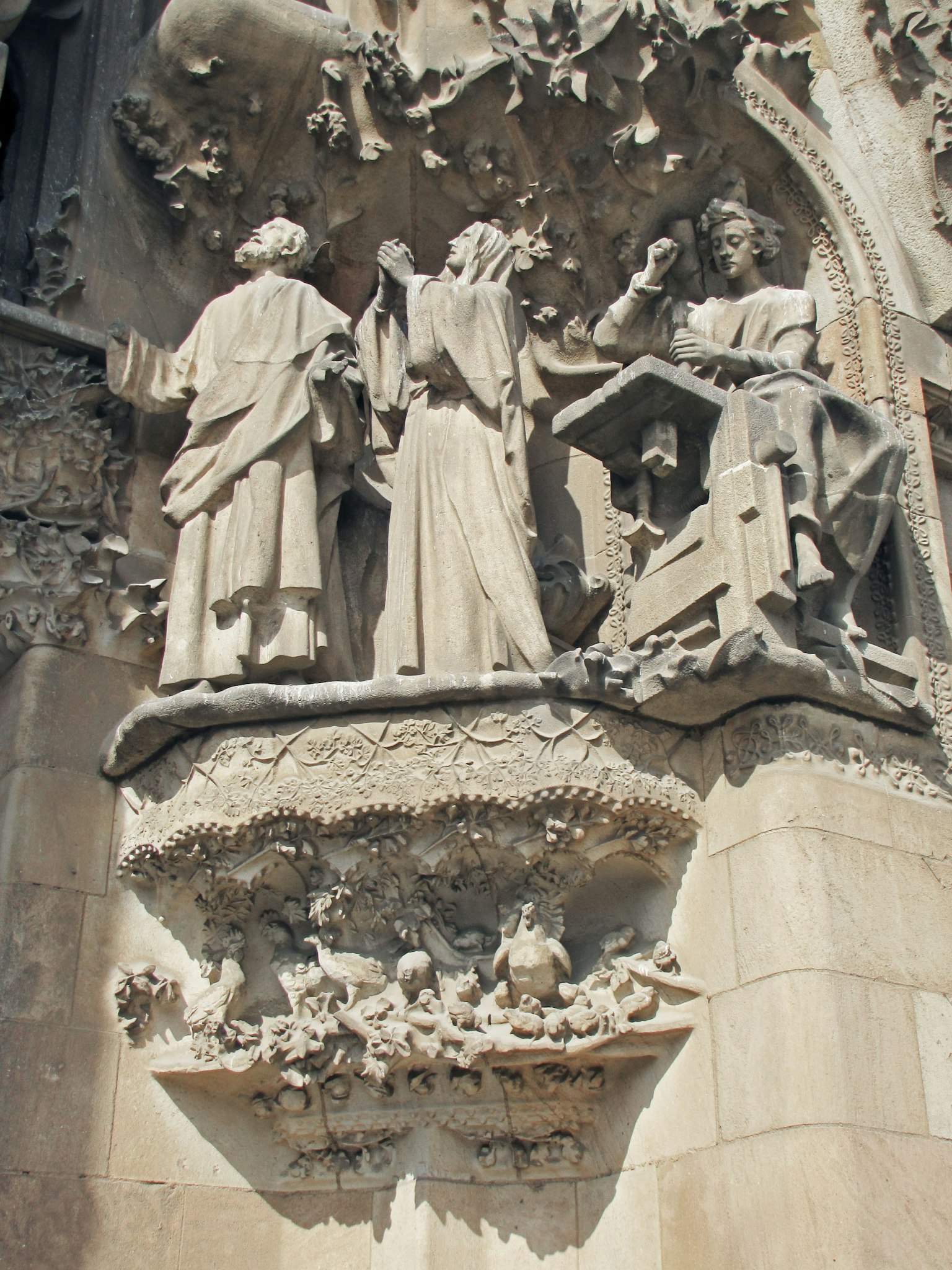 Sculptures en pierre détaillées de trois figures debout sur la Sagrada Familia