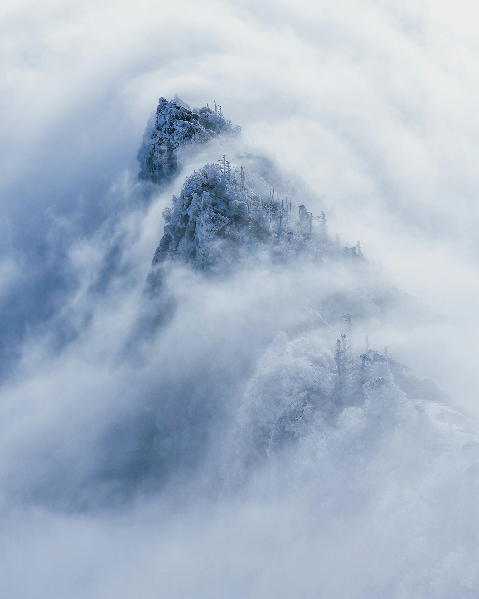 一幅美丽的风景，山峰笼罩在薄雾中