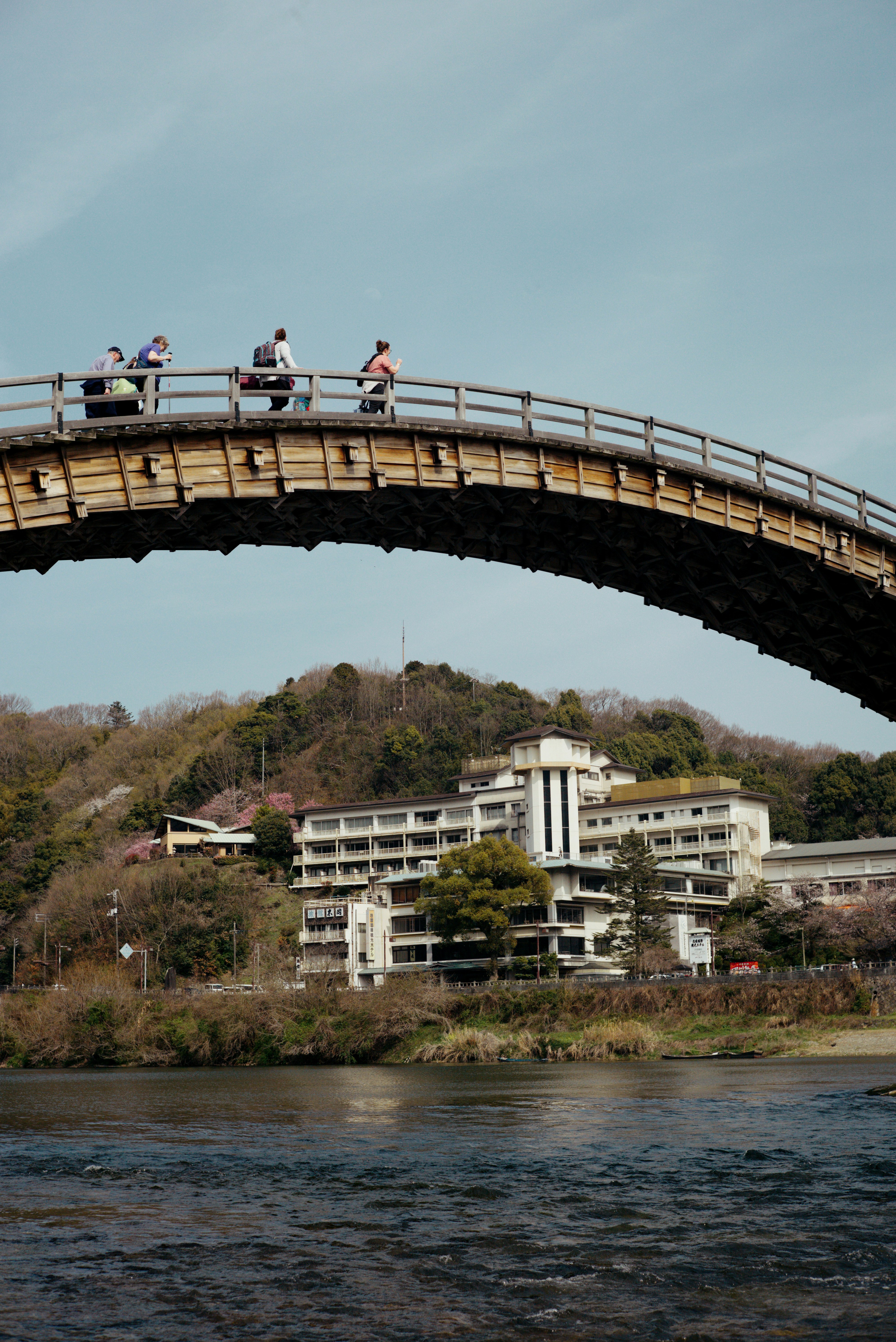 锦带桥拱形桥身跨越河面，远处山峦与建筑入镜