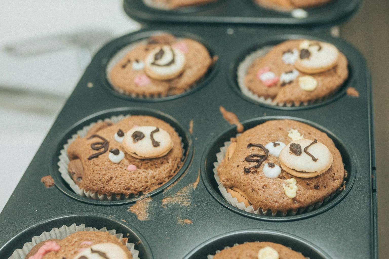 Cupcake dengan wajah hewan lucu yang dihias tersusun dalam loyang