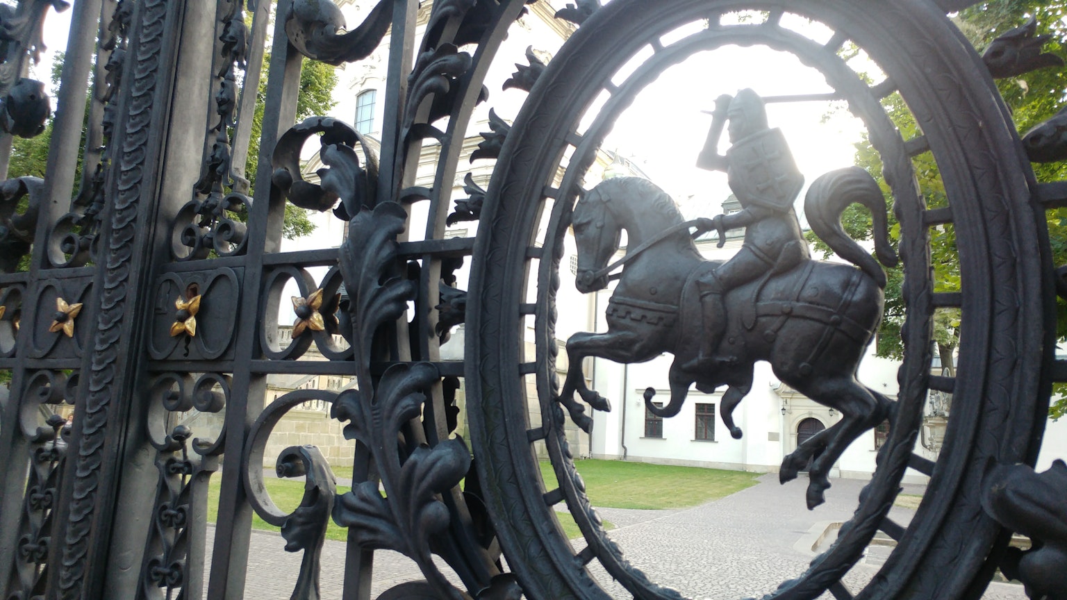 Intricate iron gate featuring a knight on horseback sculpture