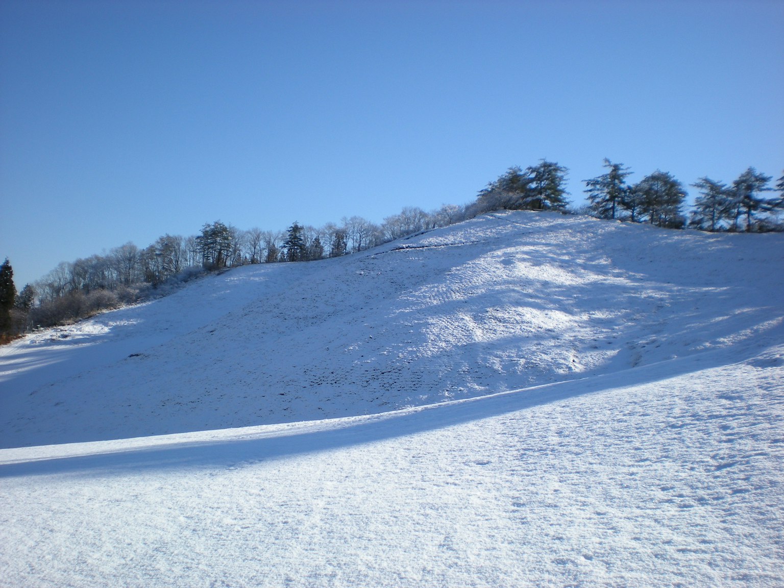 Collina coperta di neve con cielo blu chiaro