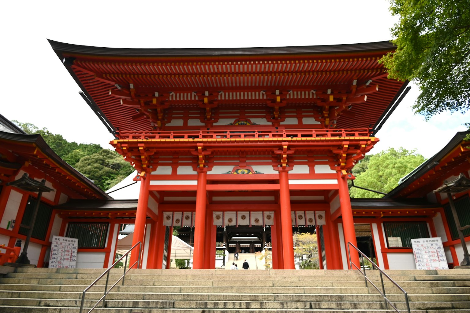 Entrance of a shrine with red pillars and roof leading up stone steps