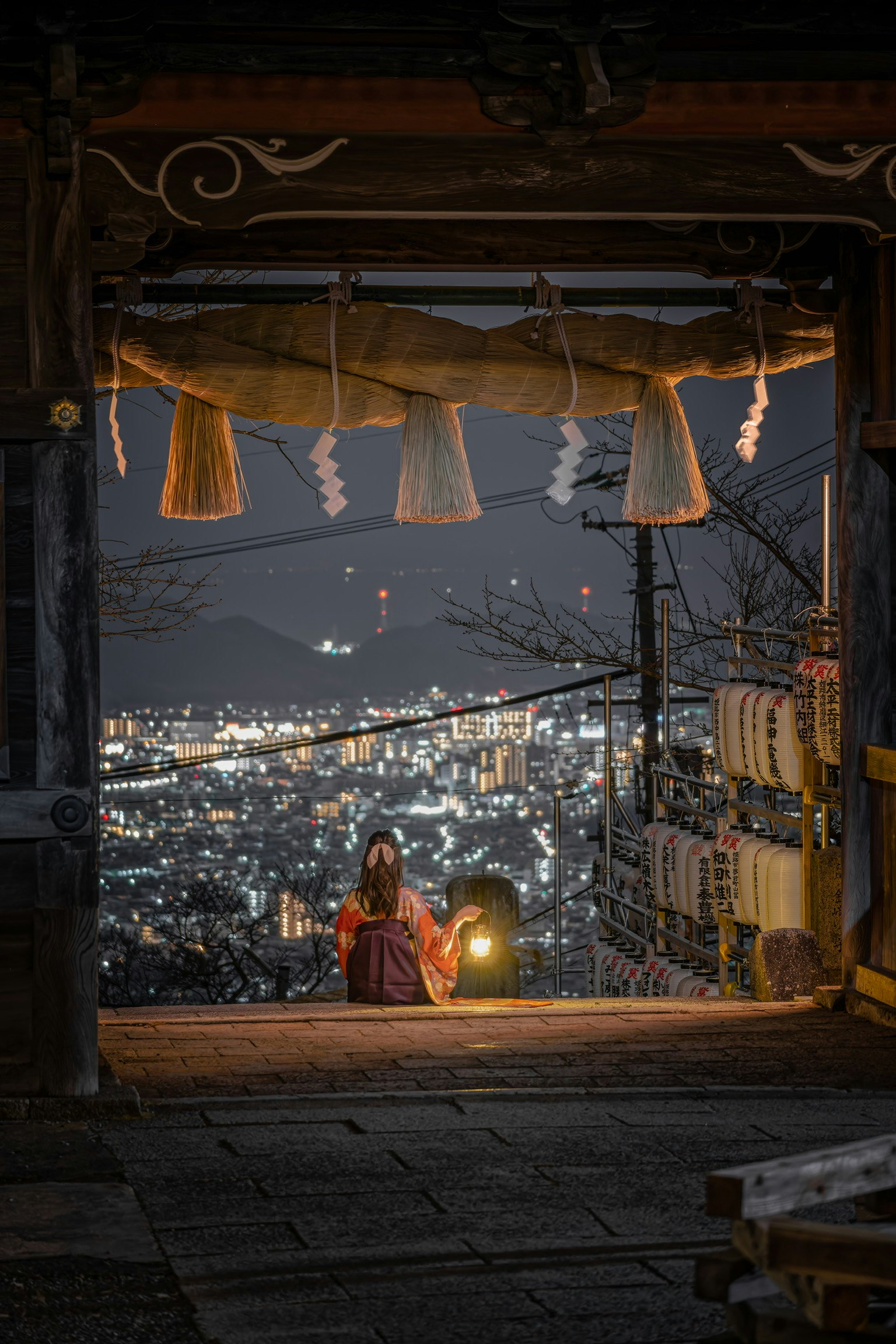 夜景を望む路地の縁側と提灯の灯り