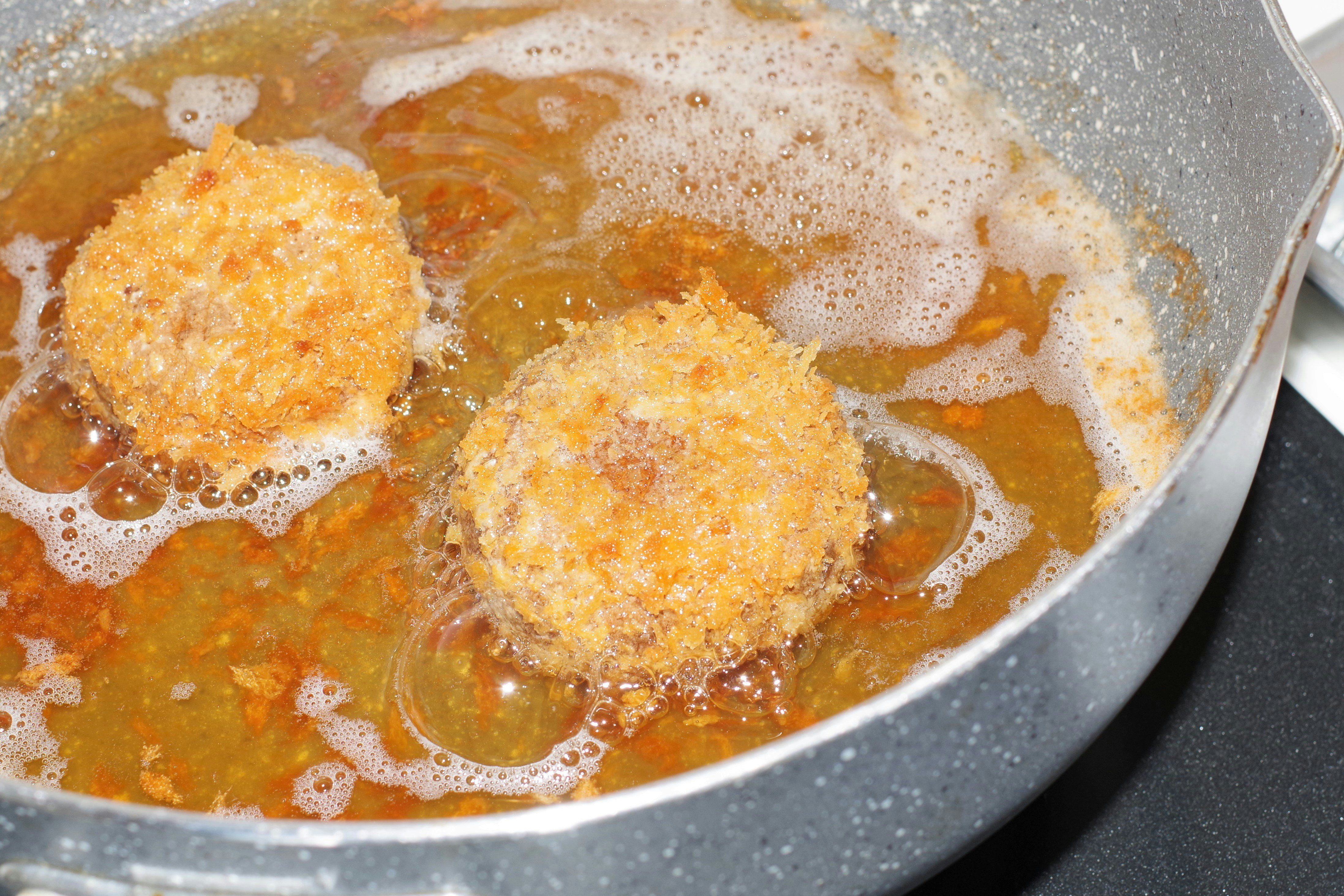 pan-fried croquette-style patties in bubbling oil