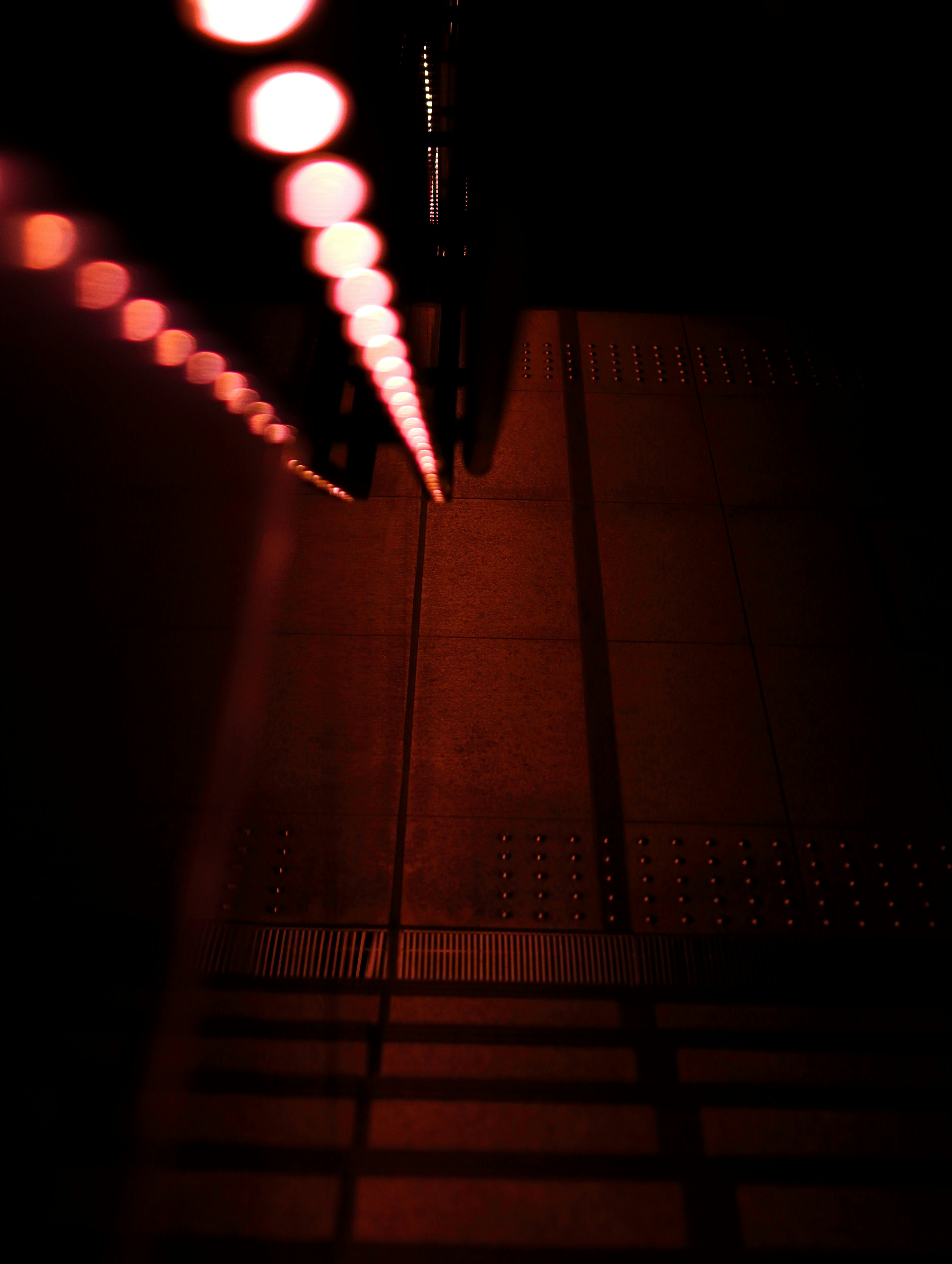 pasillo nocturno oscuro con puntos de luz en perspectiva y escaleras