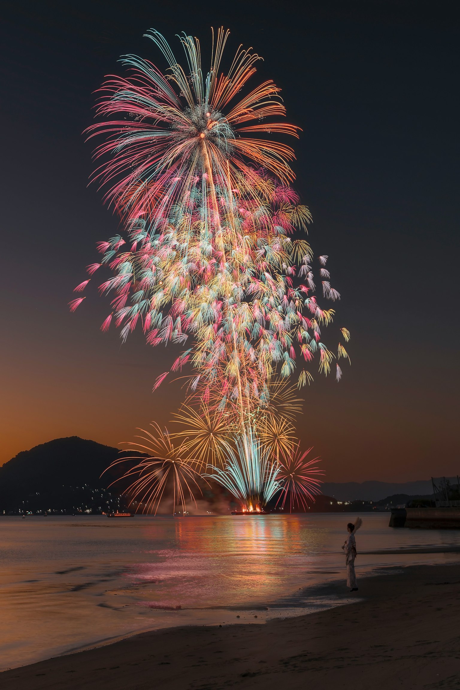 Spectacle de feux d'artifice colorés sur la plage au crépuscule