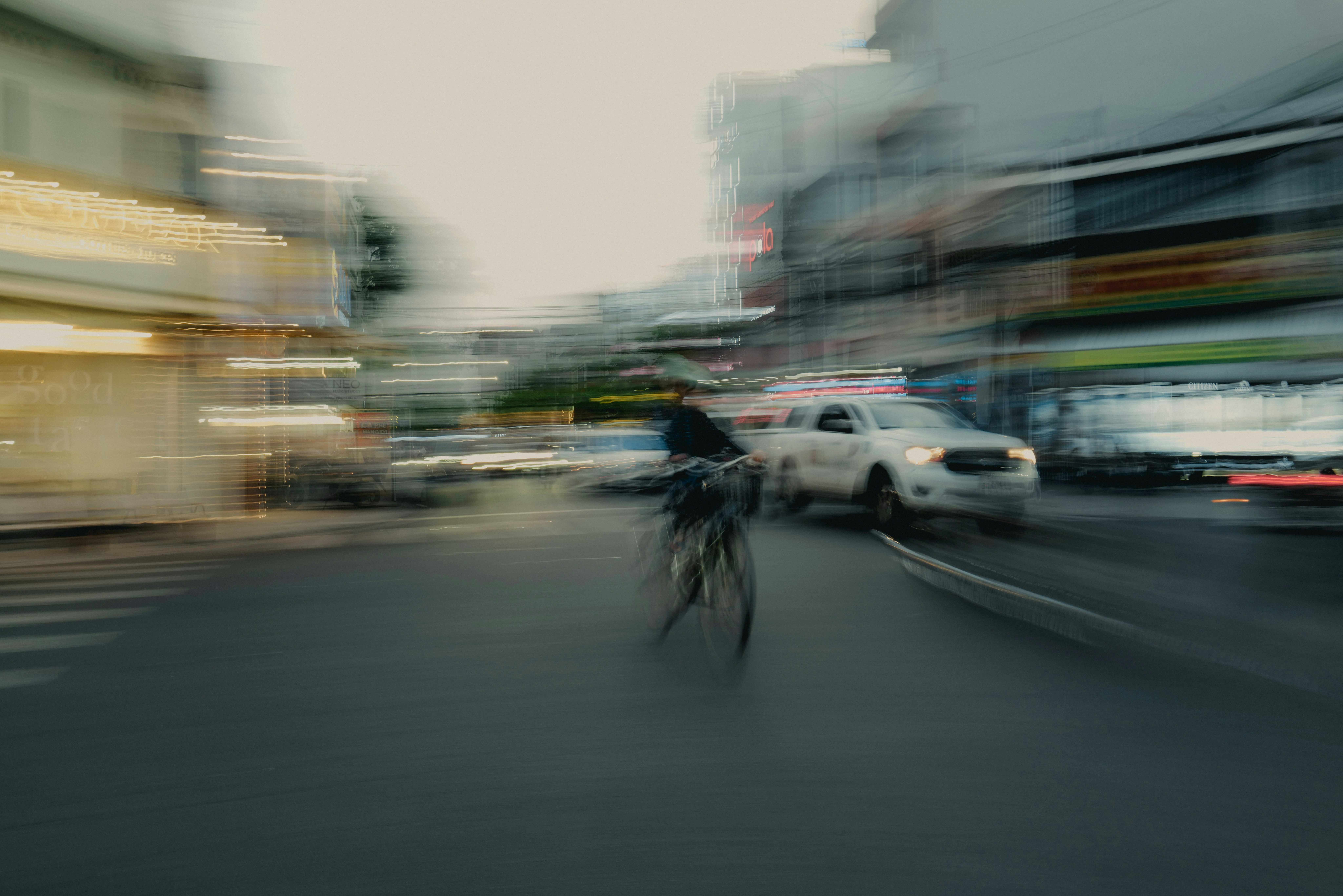 車とバイクが行き交う都市の通りの流し撮り