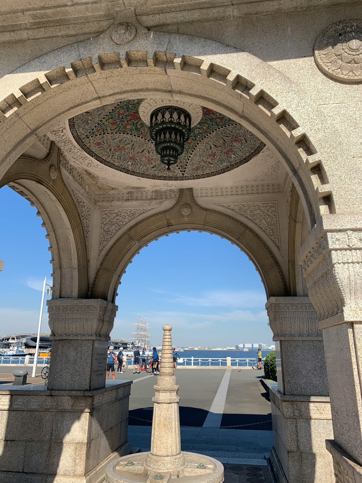 Architettura storica con belle arcate e una lampada decorativa, vista sul mare e sul cielo sullo sfondo