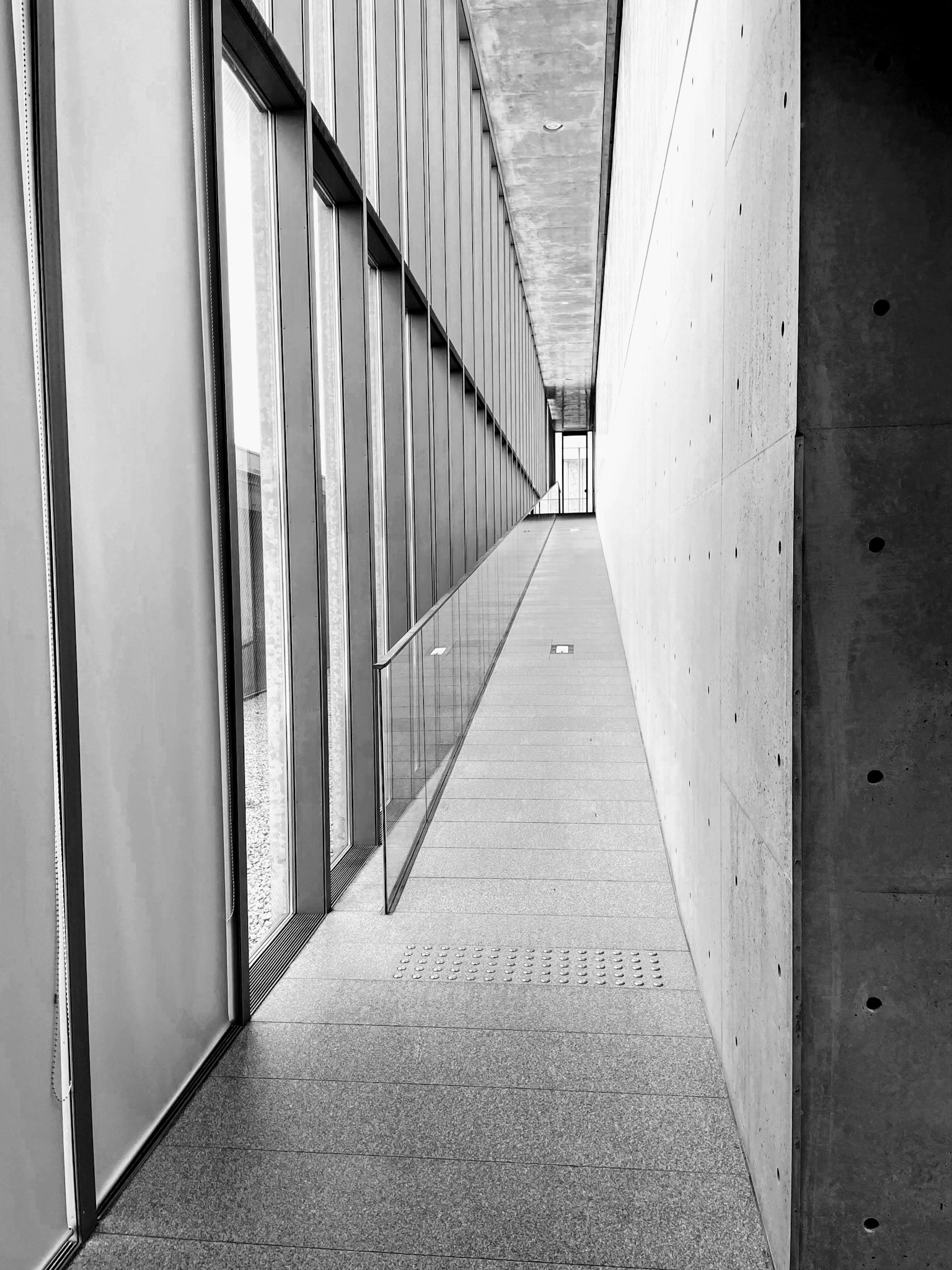 Sebuah lorong modern yang ramping dengan elemen beton dan kaca