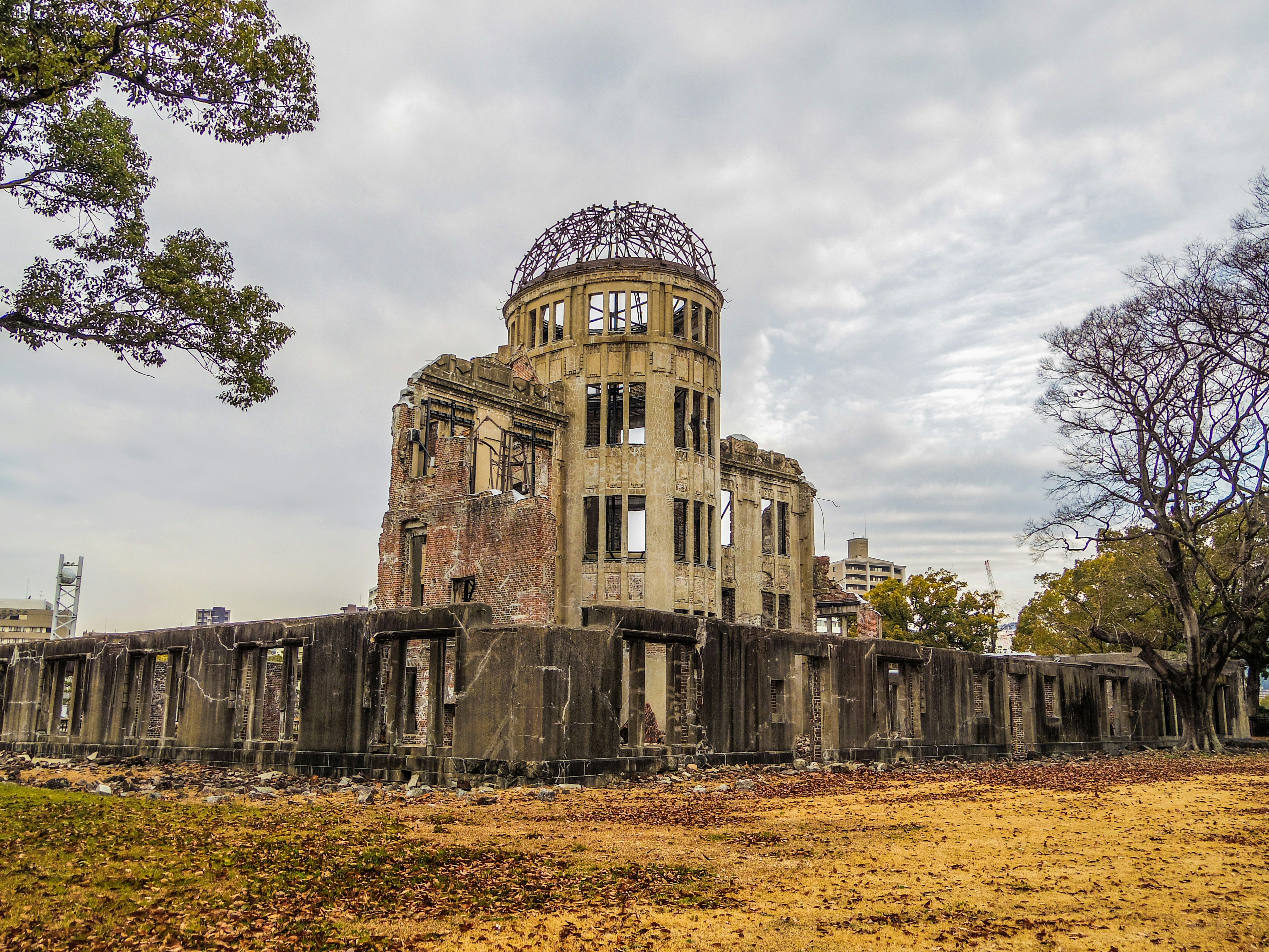Ruinas del Genbaku Dome con árboles y plaza cercana