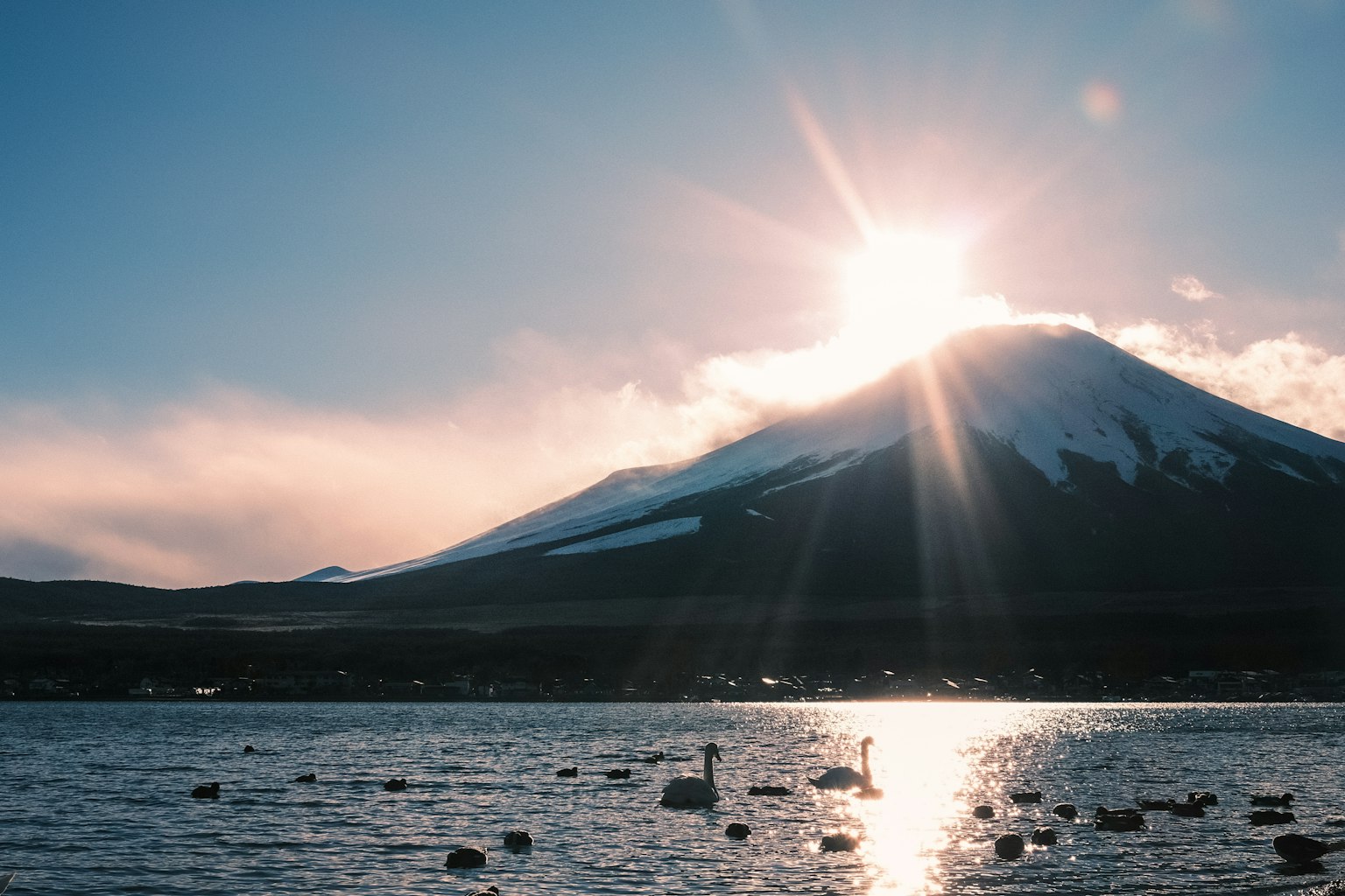 Scenic view of Mount Fuji with sunlight and water reflections