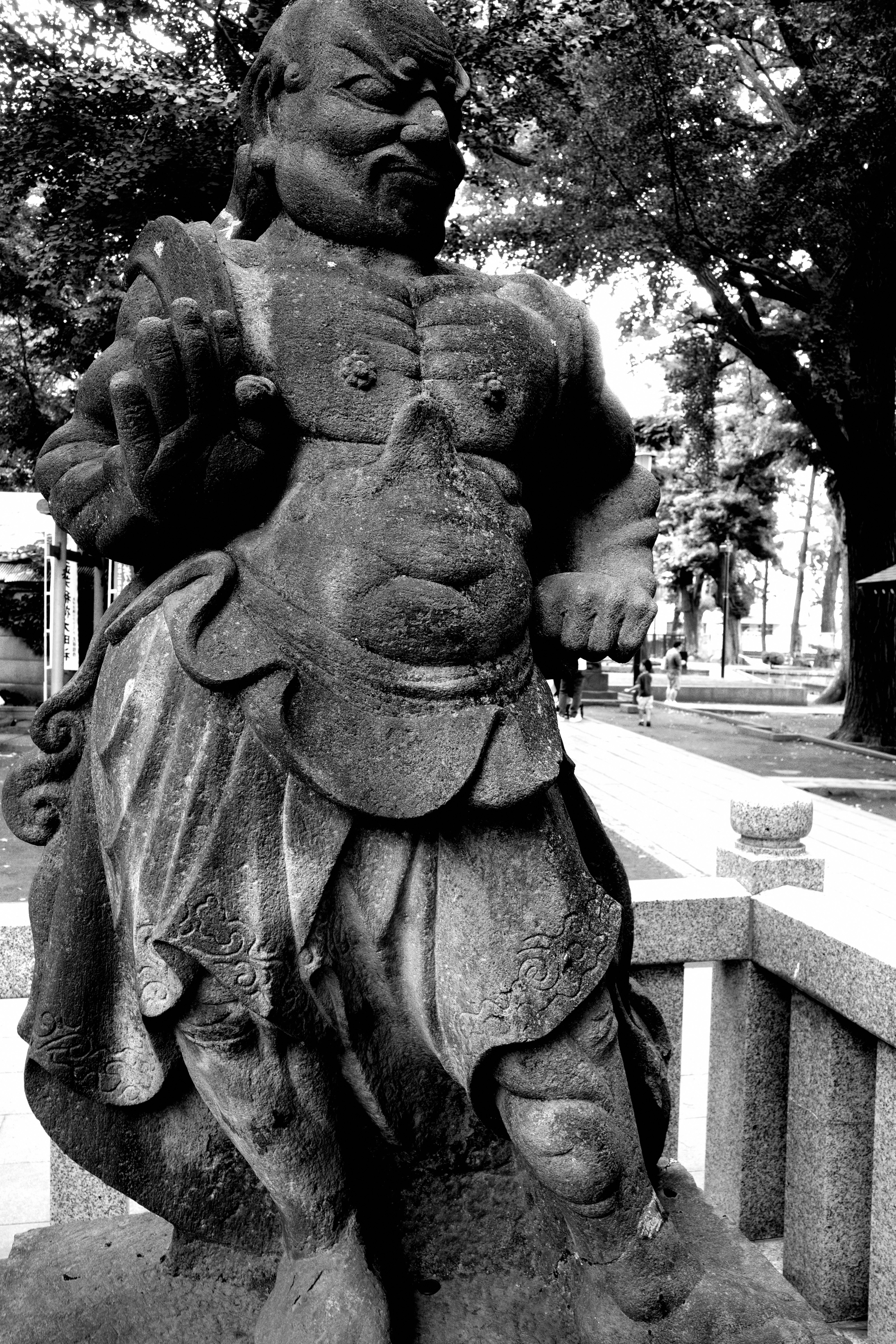 patung batu pahatan sosok manusia di taman