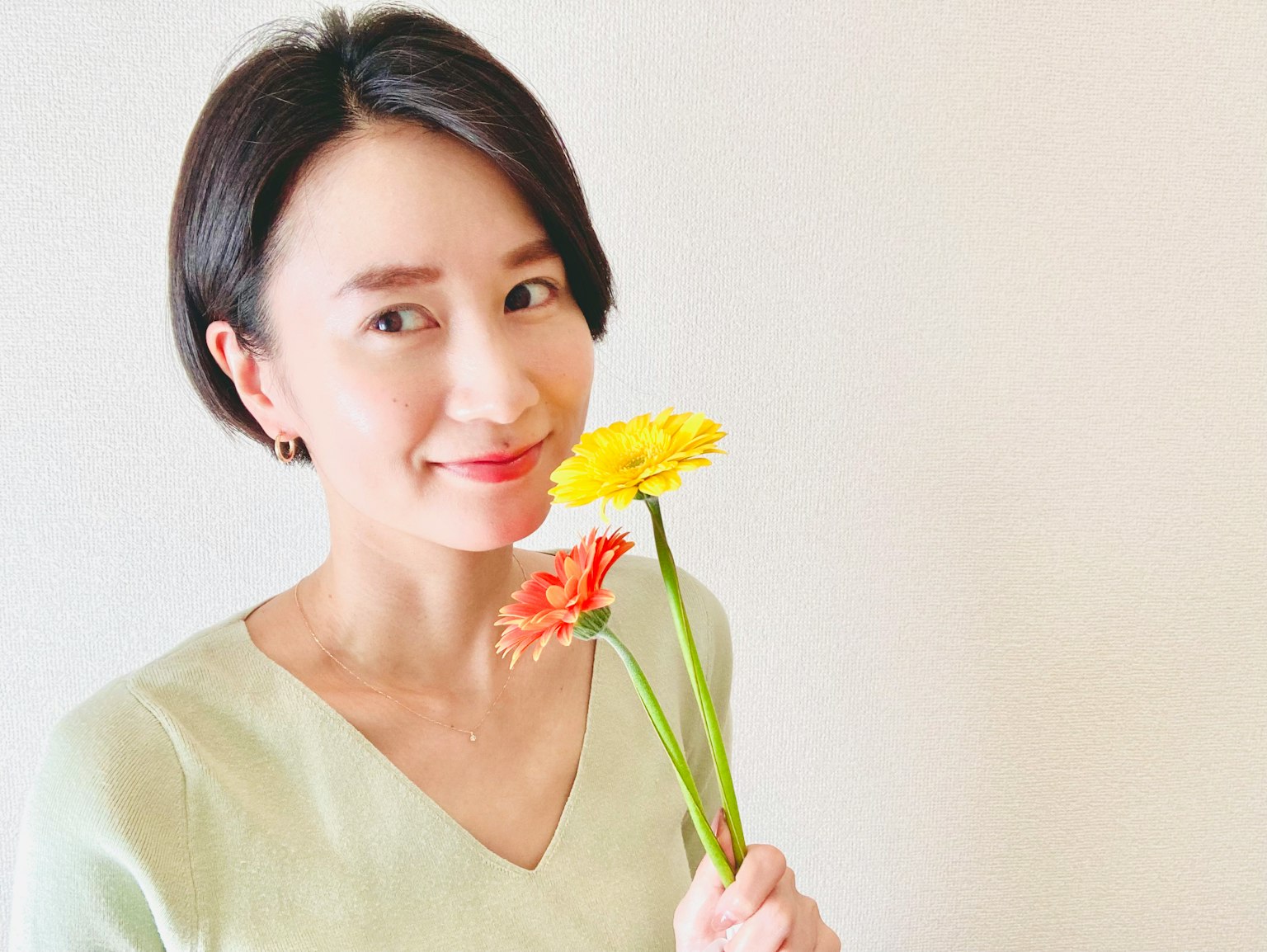 Portrait of a woman holding flowers Smiling expression Bright background